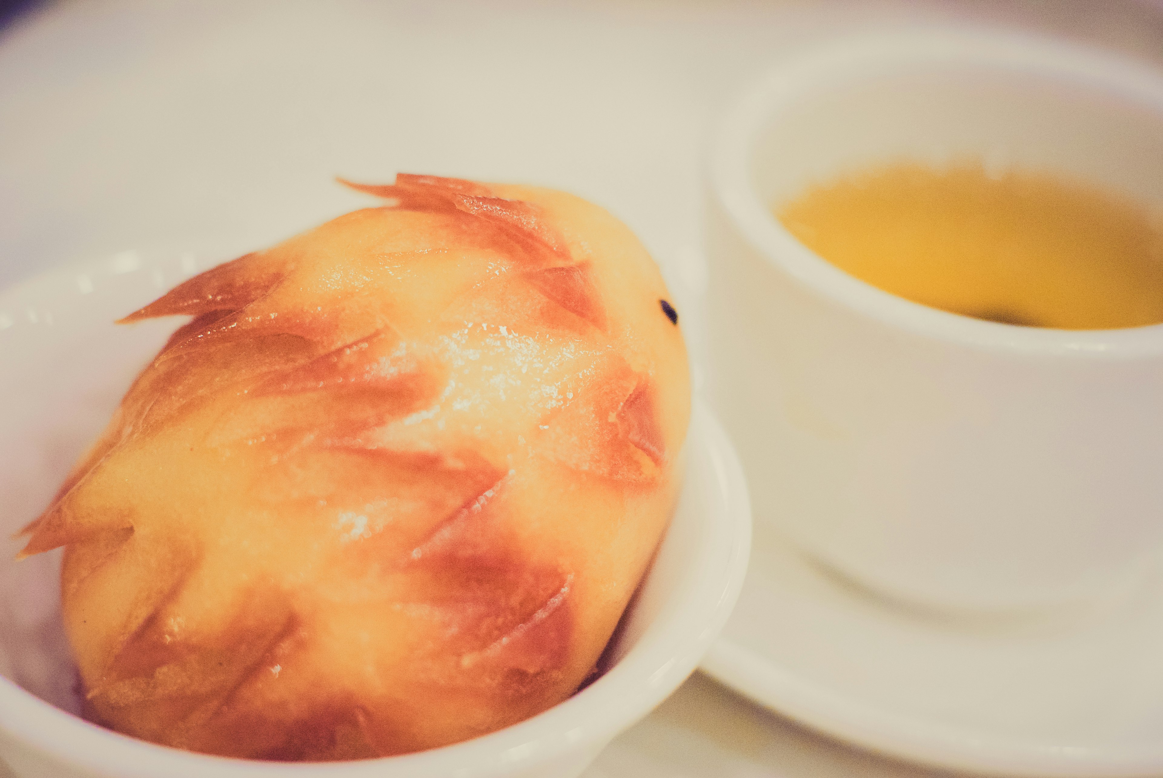 Pastel recién horneado junto a una taza de bebida amarilla