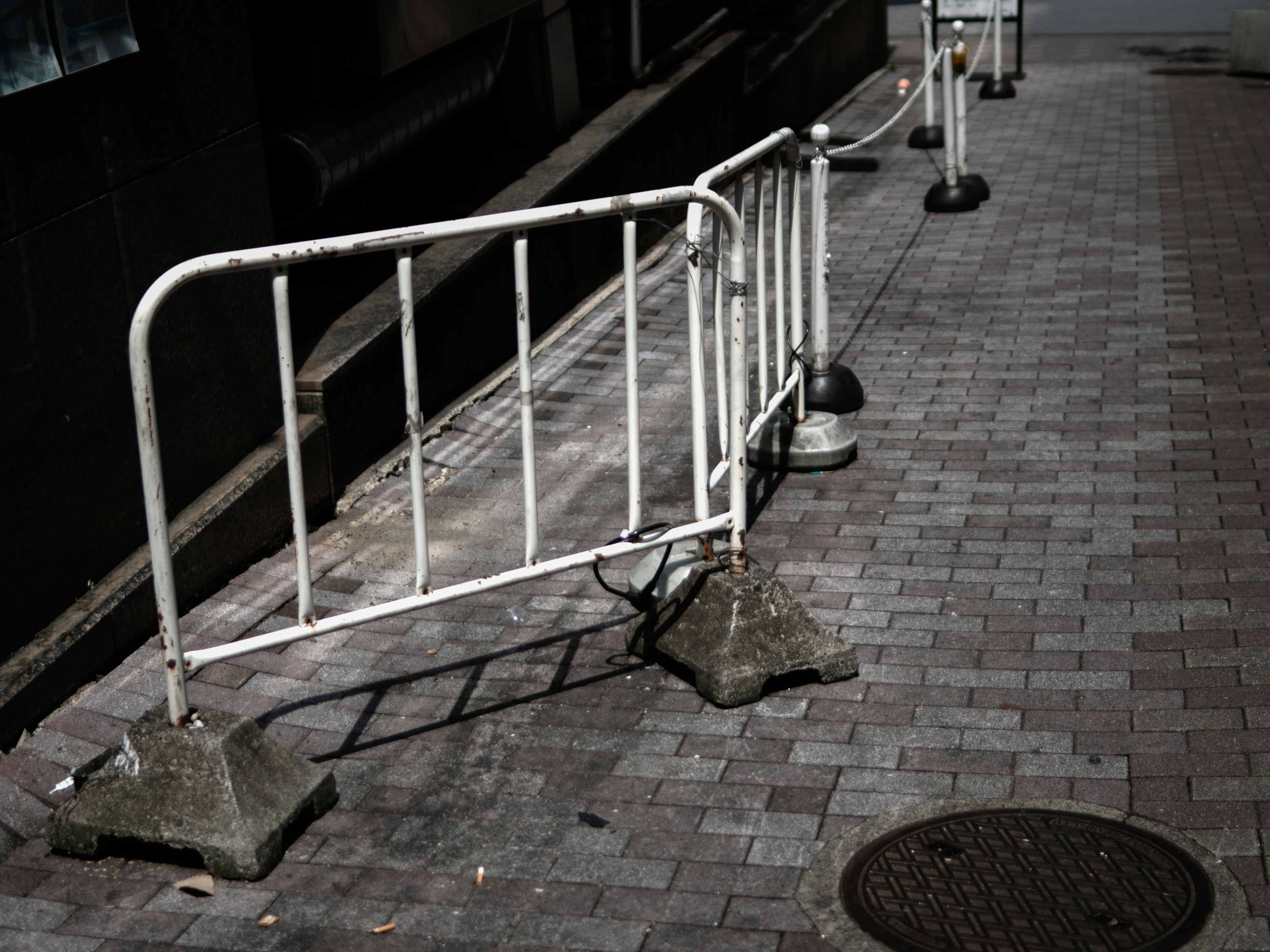 白いバリケードと石畳の道の風景