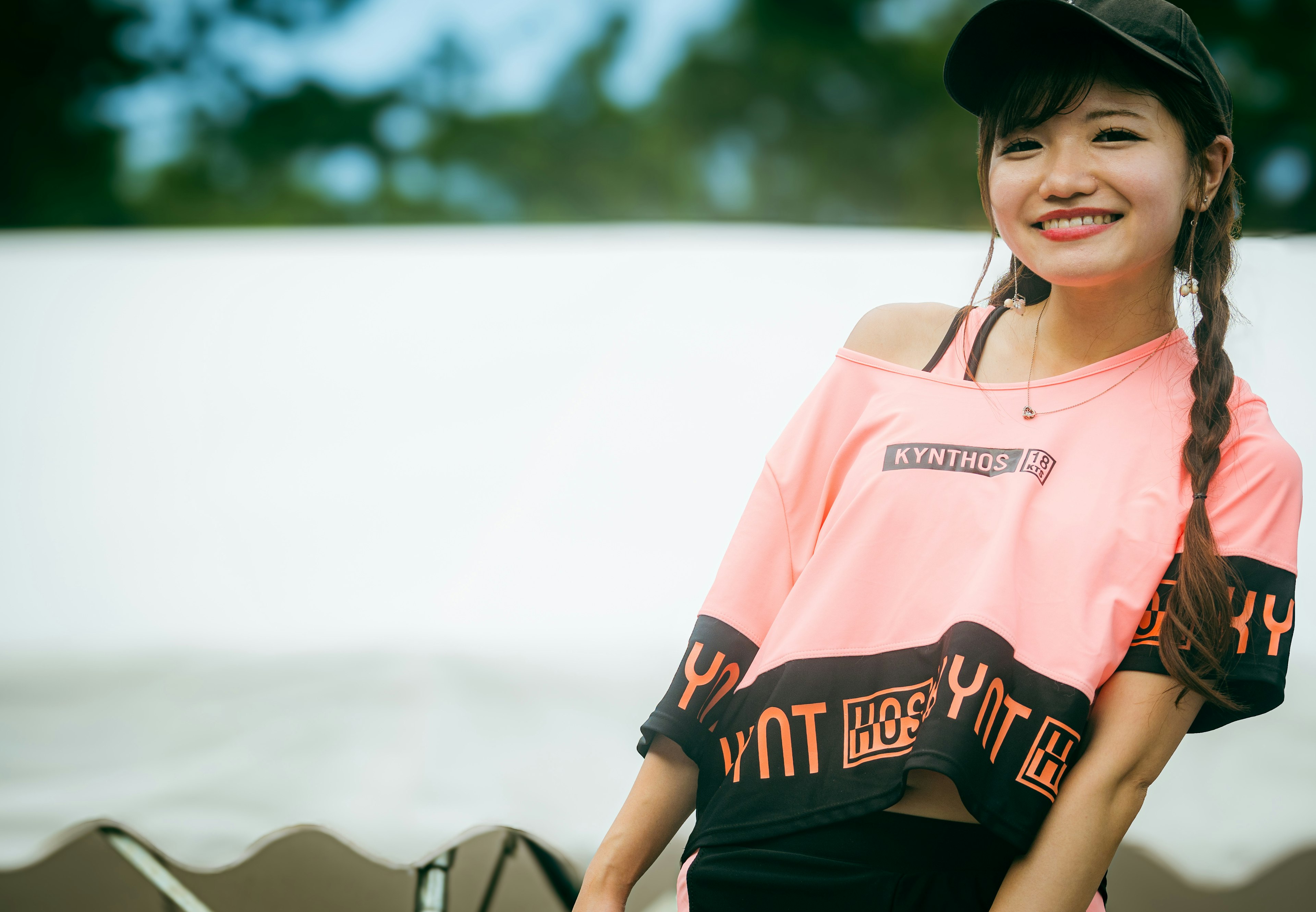 Smiling woman wearing pink sportswear with a trendy design in a natural outdoor setting