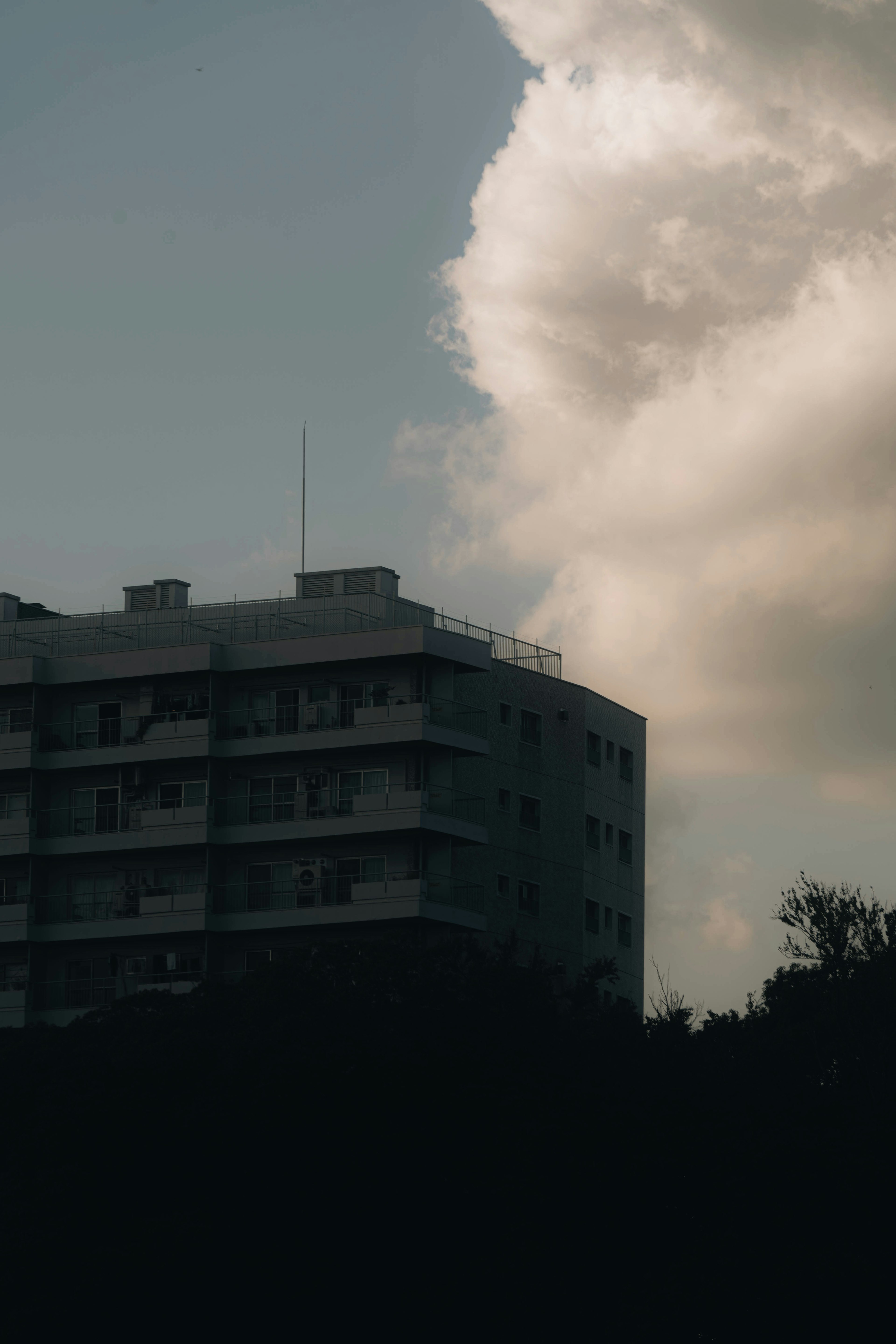 Edificio moderno in silhouette contro un cielo nuvoloso