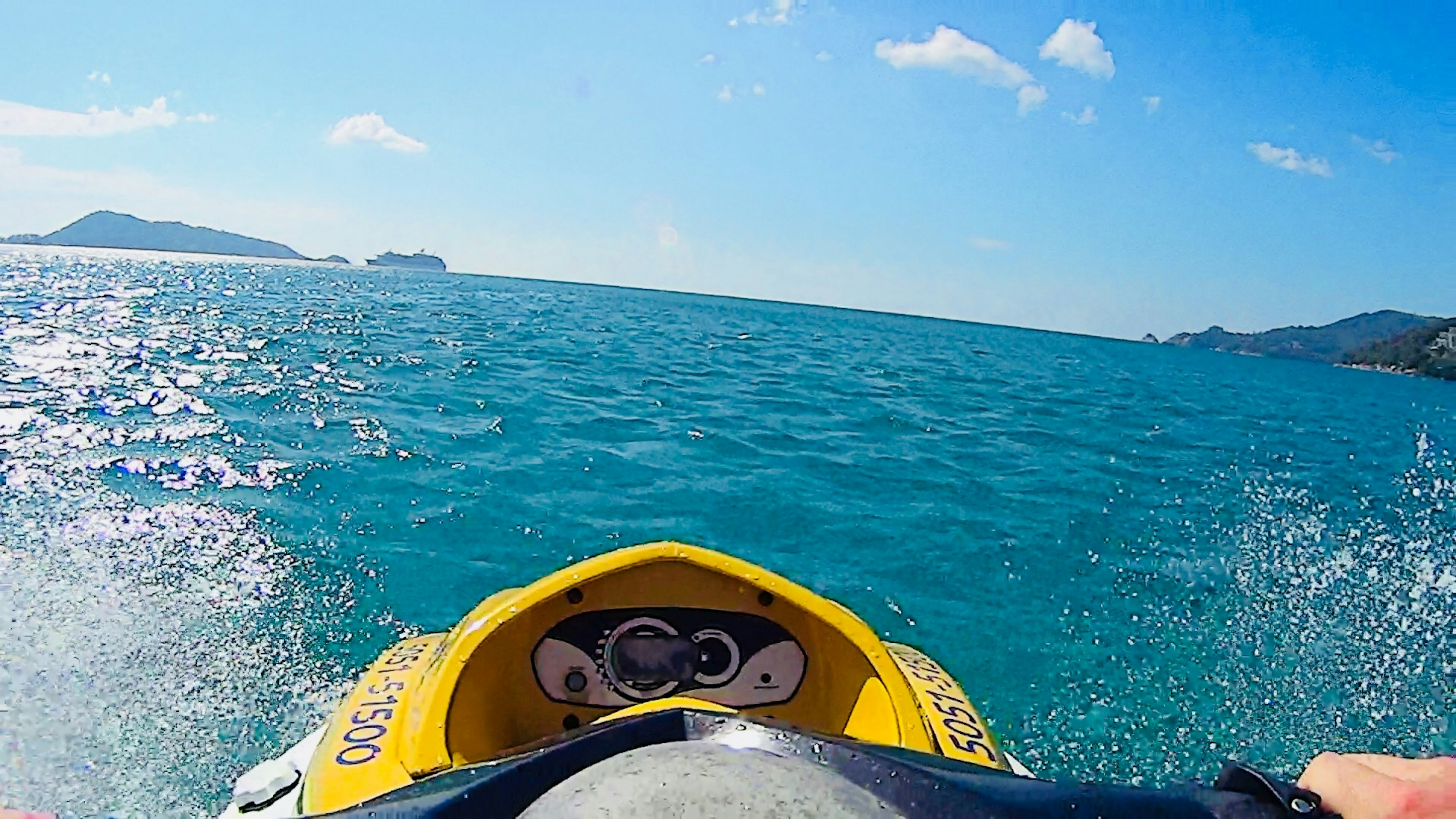 View from a jet ski riding over turquoise waters under a clear sky