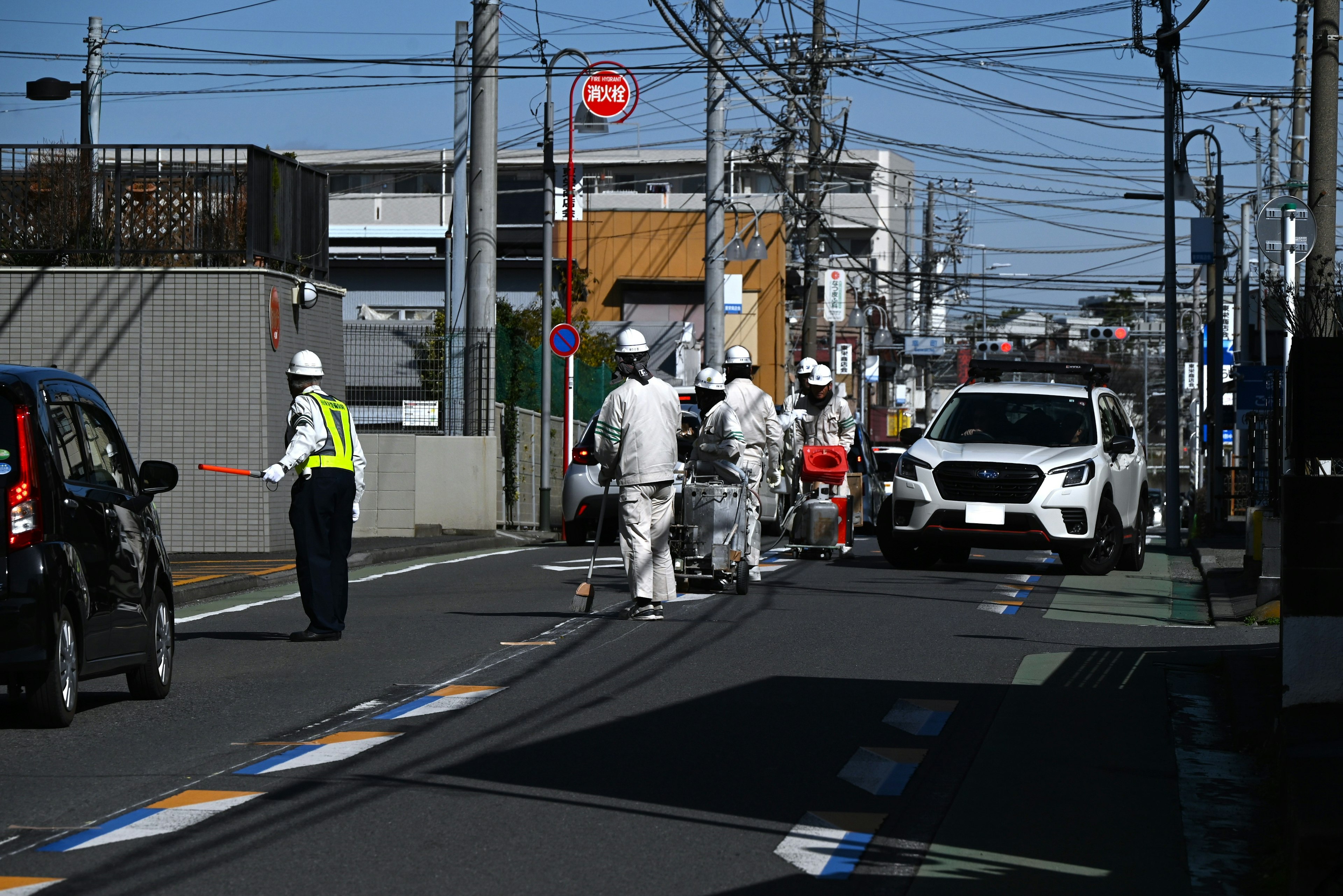 工人在进行道路维护，交通警察指挥车辆