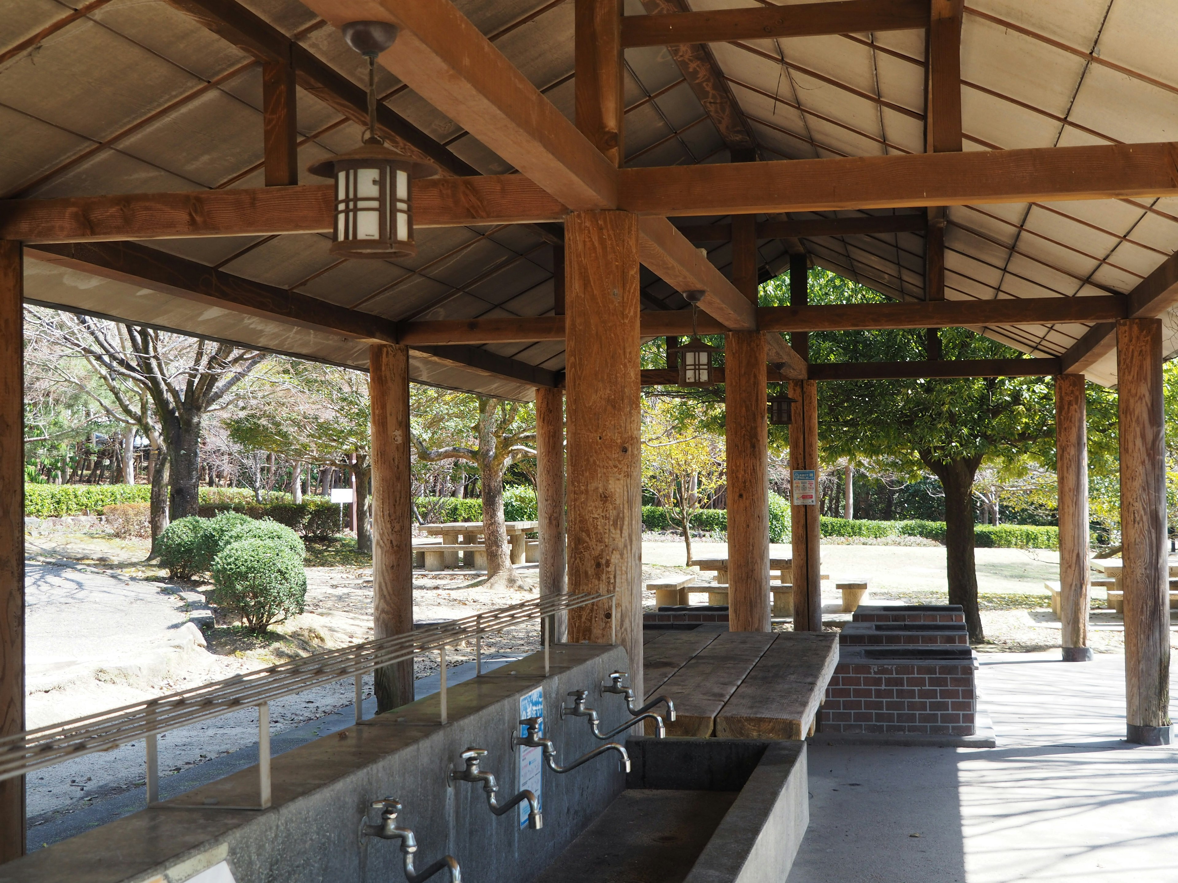 Station d'eau avec toit en bois et vue sur un parc verdoyant