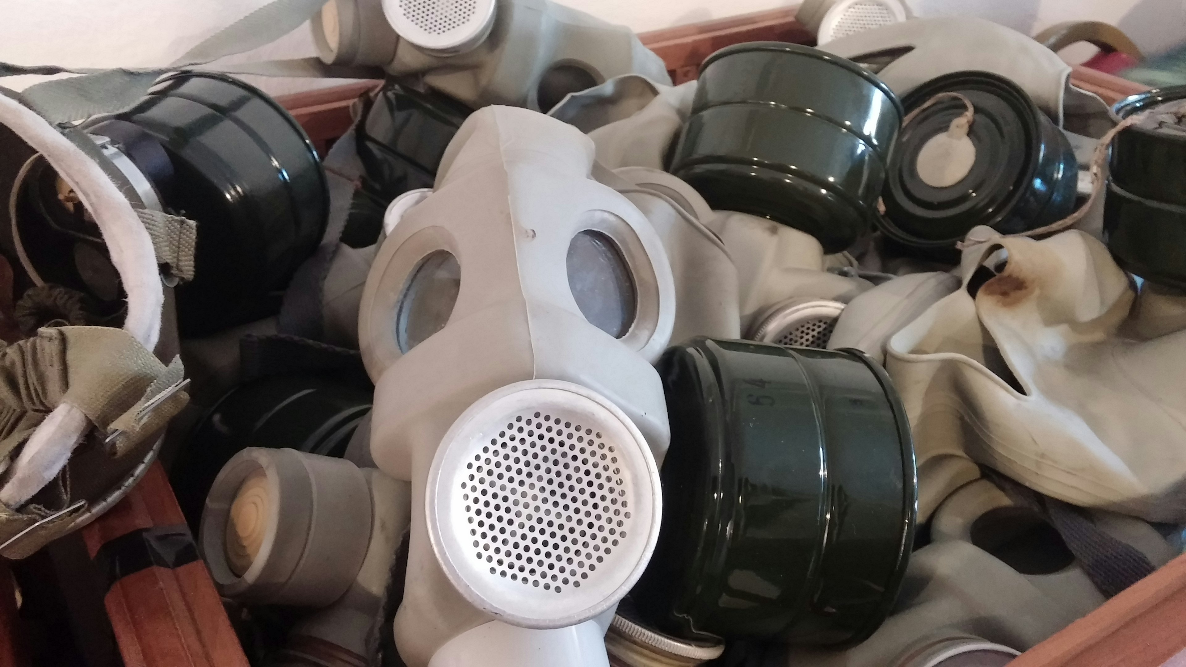 Image présentant des masques à gaz et des canisters verts entassés