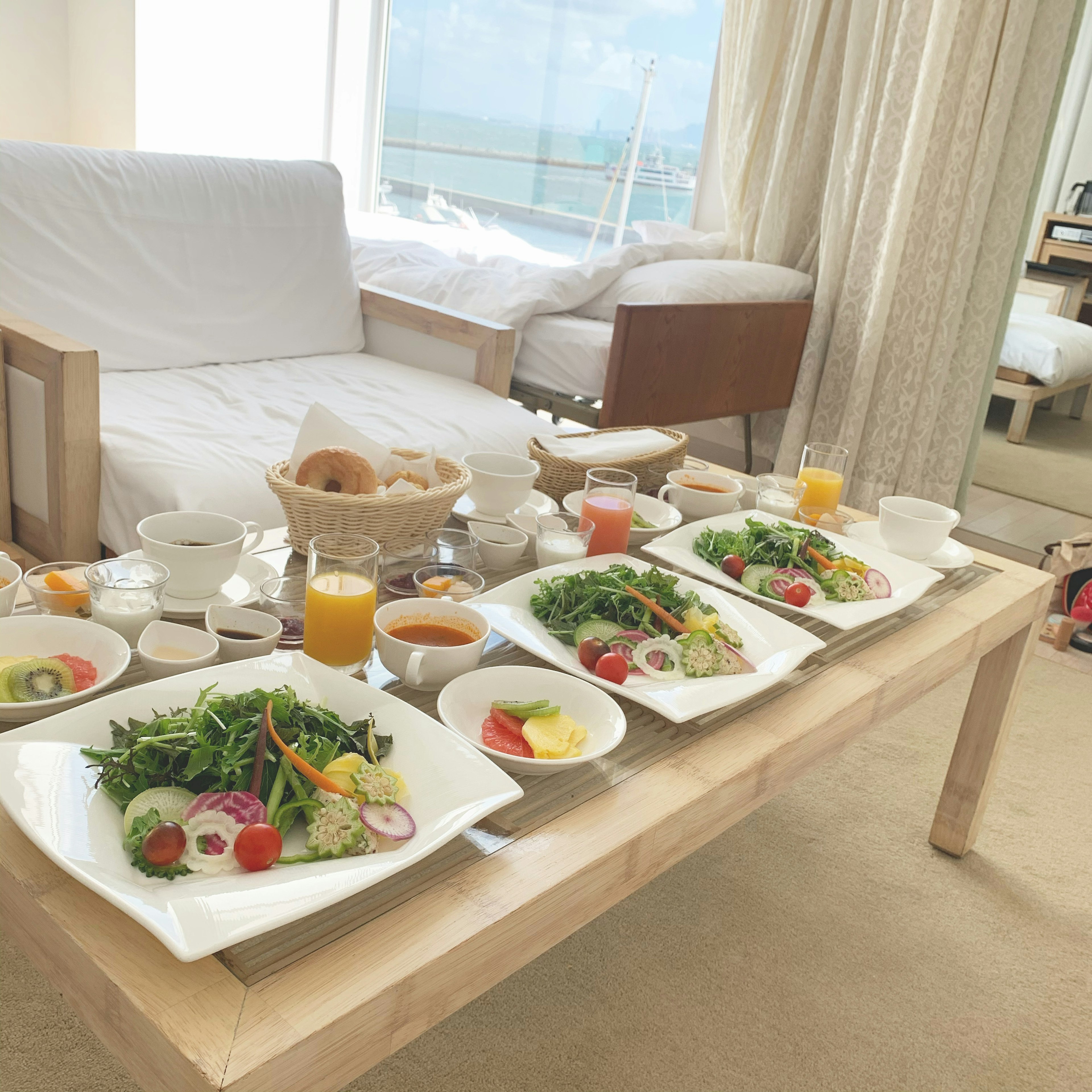 Frühstückstisch in einem Hotelzimmer mit Salaten und Saft