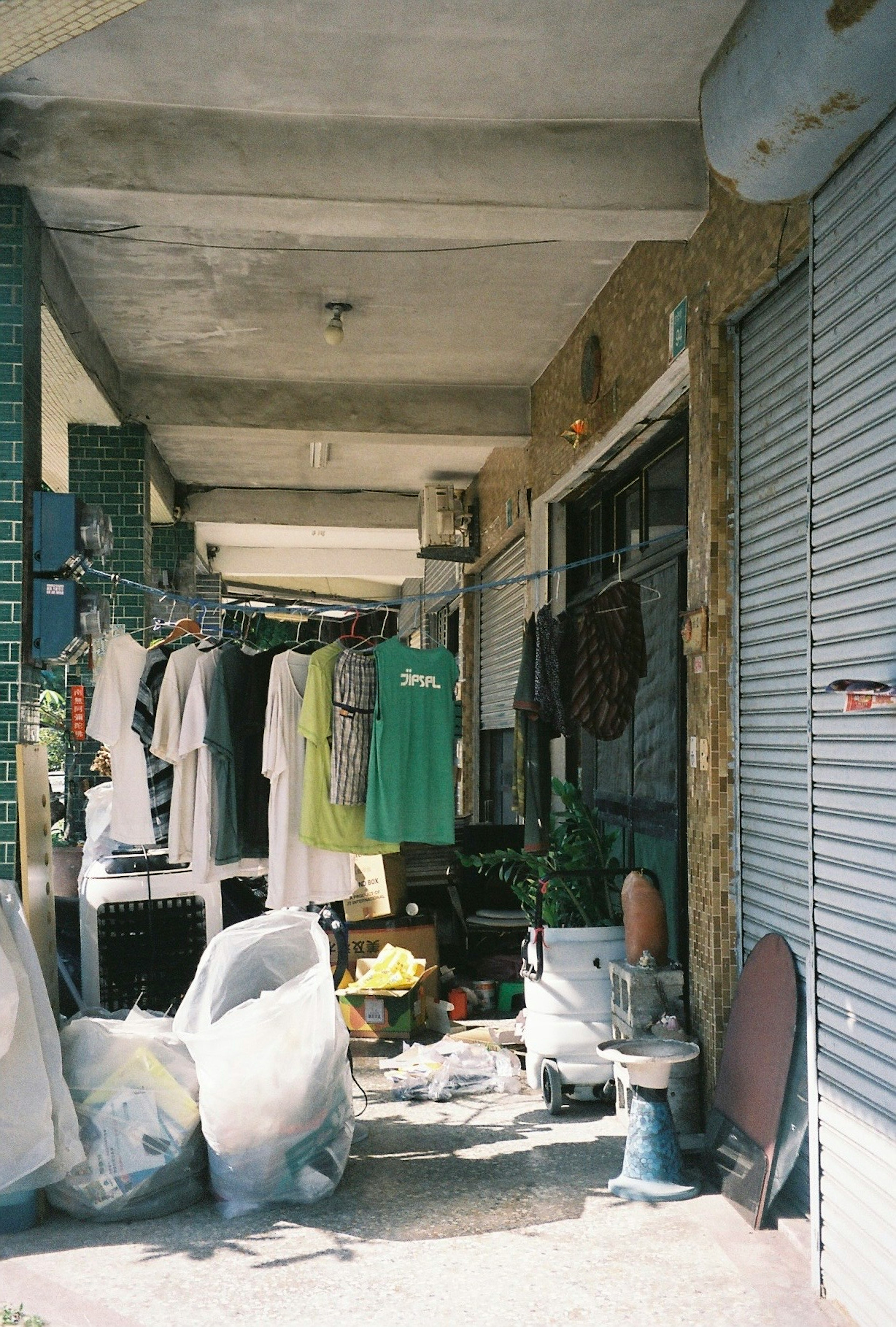 Vista de un arcade con ropa colgada y bolsas de basura alineadas