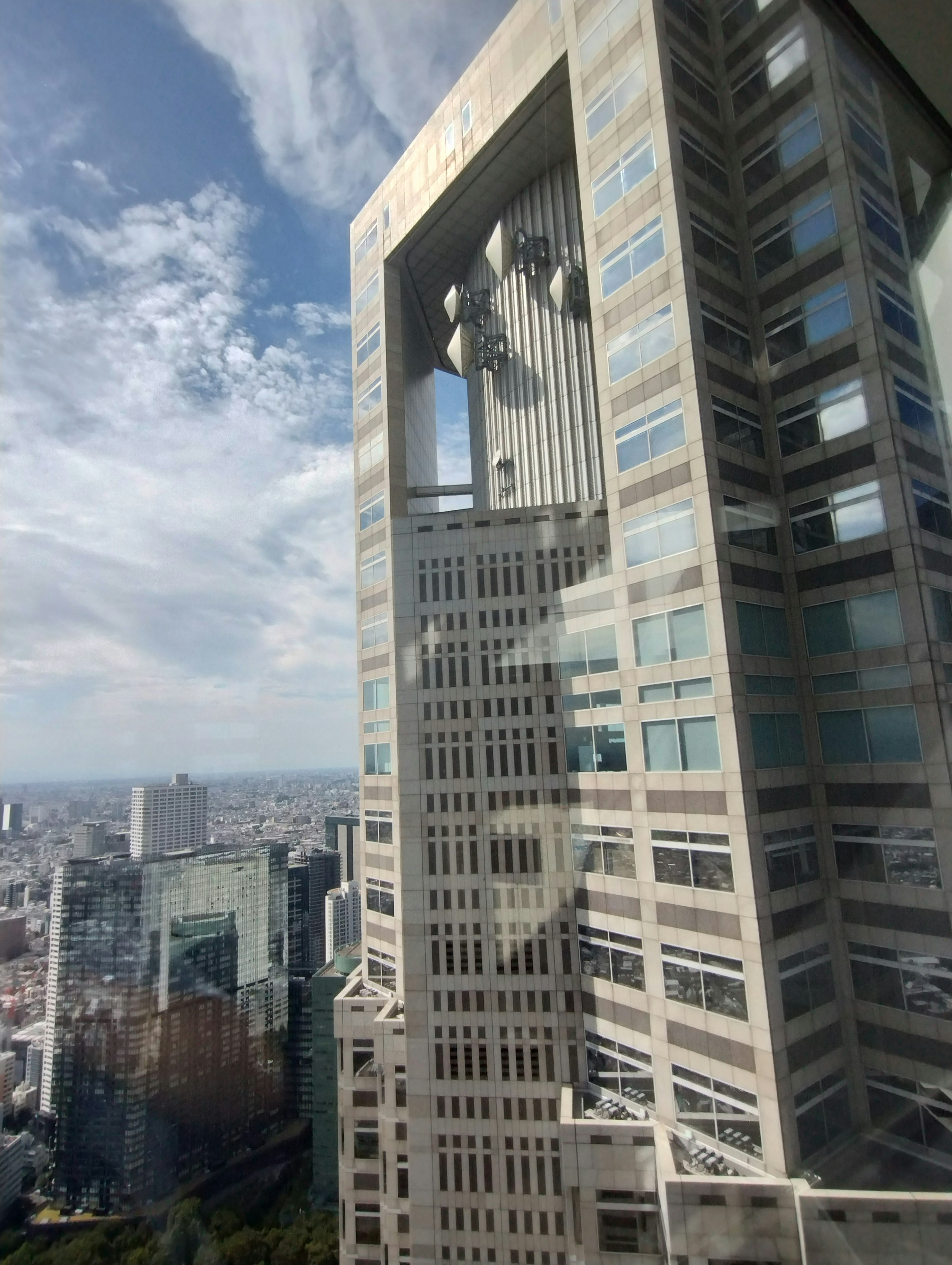 Gedung pencakar langit dengan desain unik menunjukkan pemandangan kota dengan awan