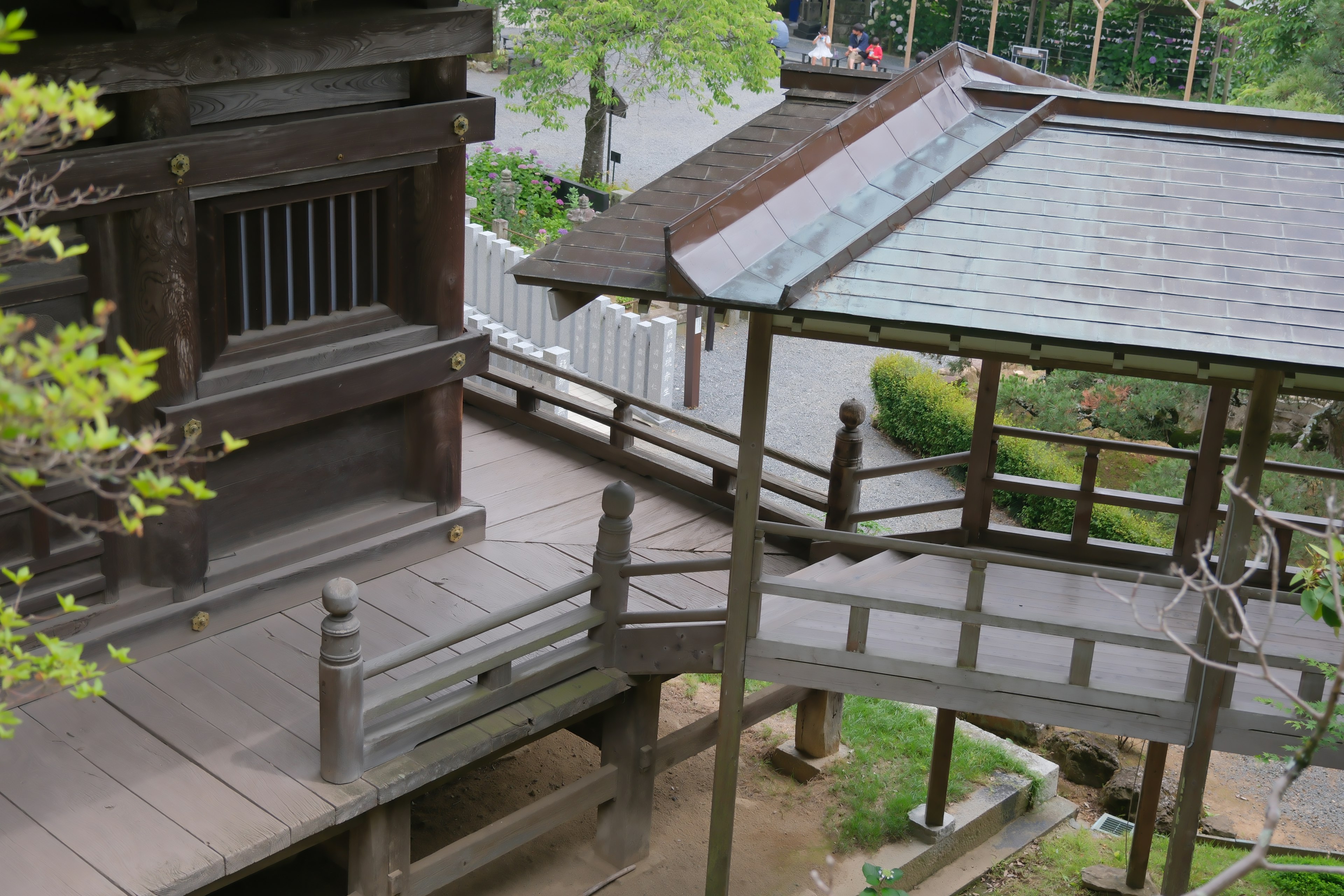 木造の伝統的な建物と橋を含む日本庭園の景観