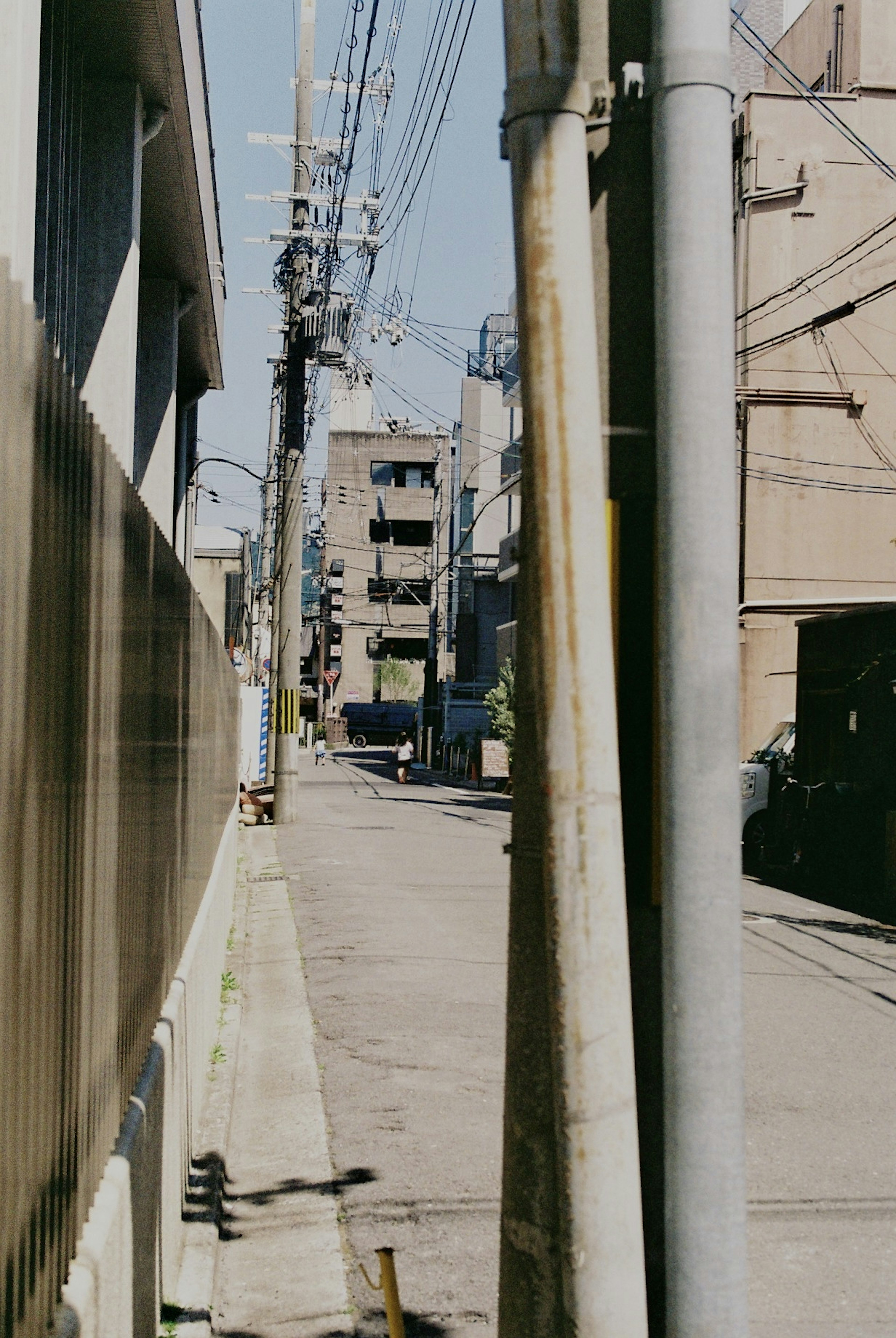 狭い路地にある建物と電線が見える風景