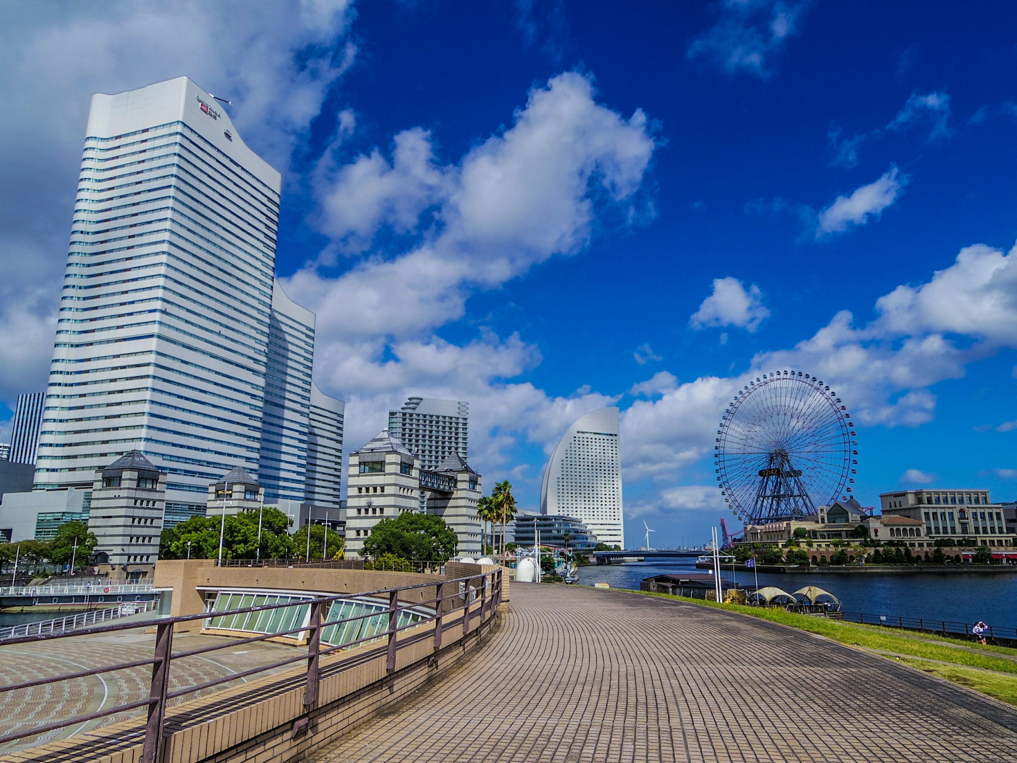 Blick auf die Uferpromenade von Yokohama mit Wolkenkratzern und blauem Himmel