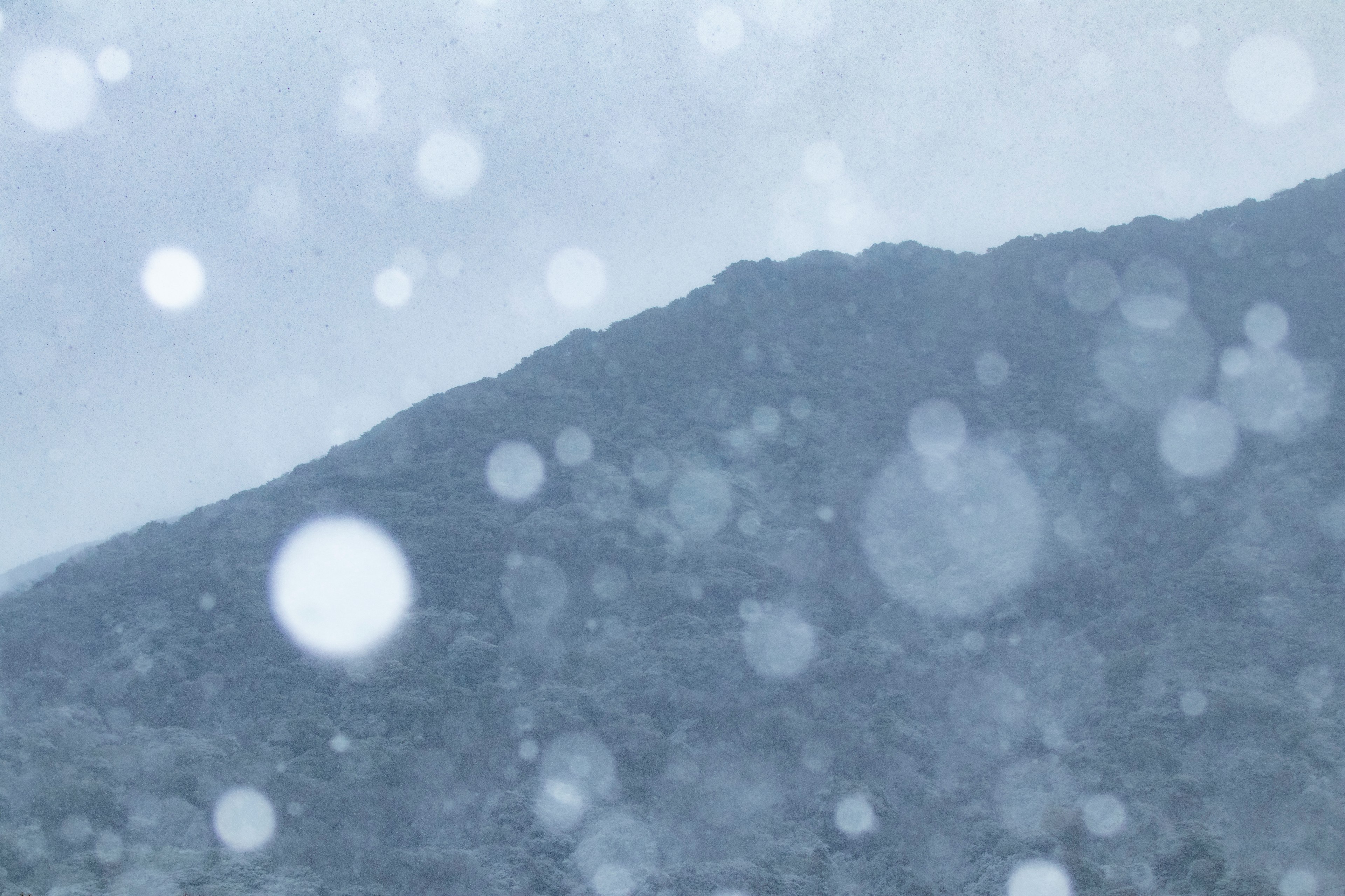 雪の降る山の景色とぼんやりした背景