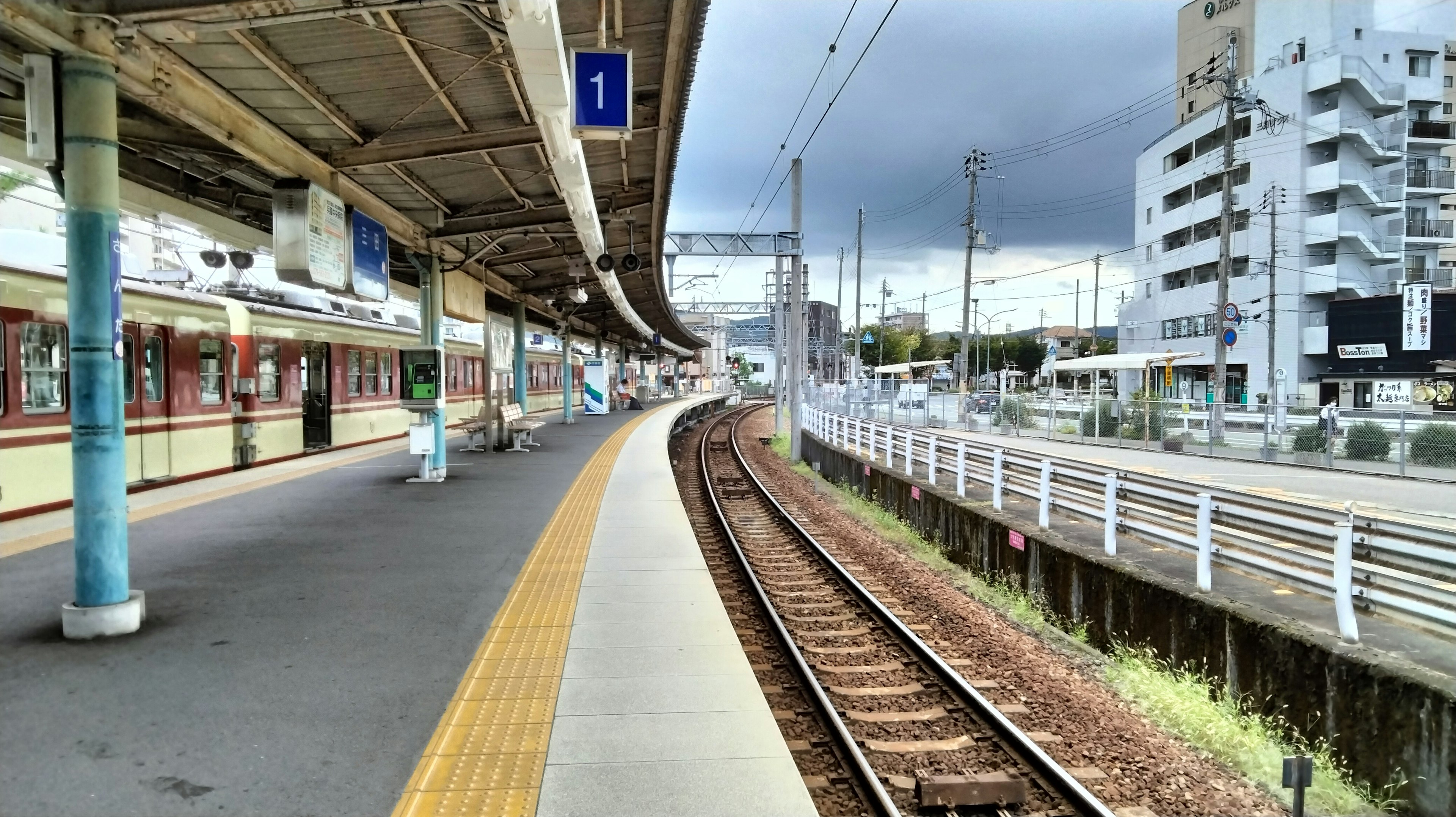 Vista di una piattaforma ferroviaria con binari curvi e edifici vicini