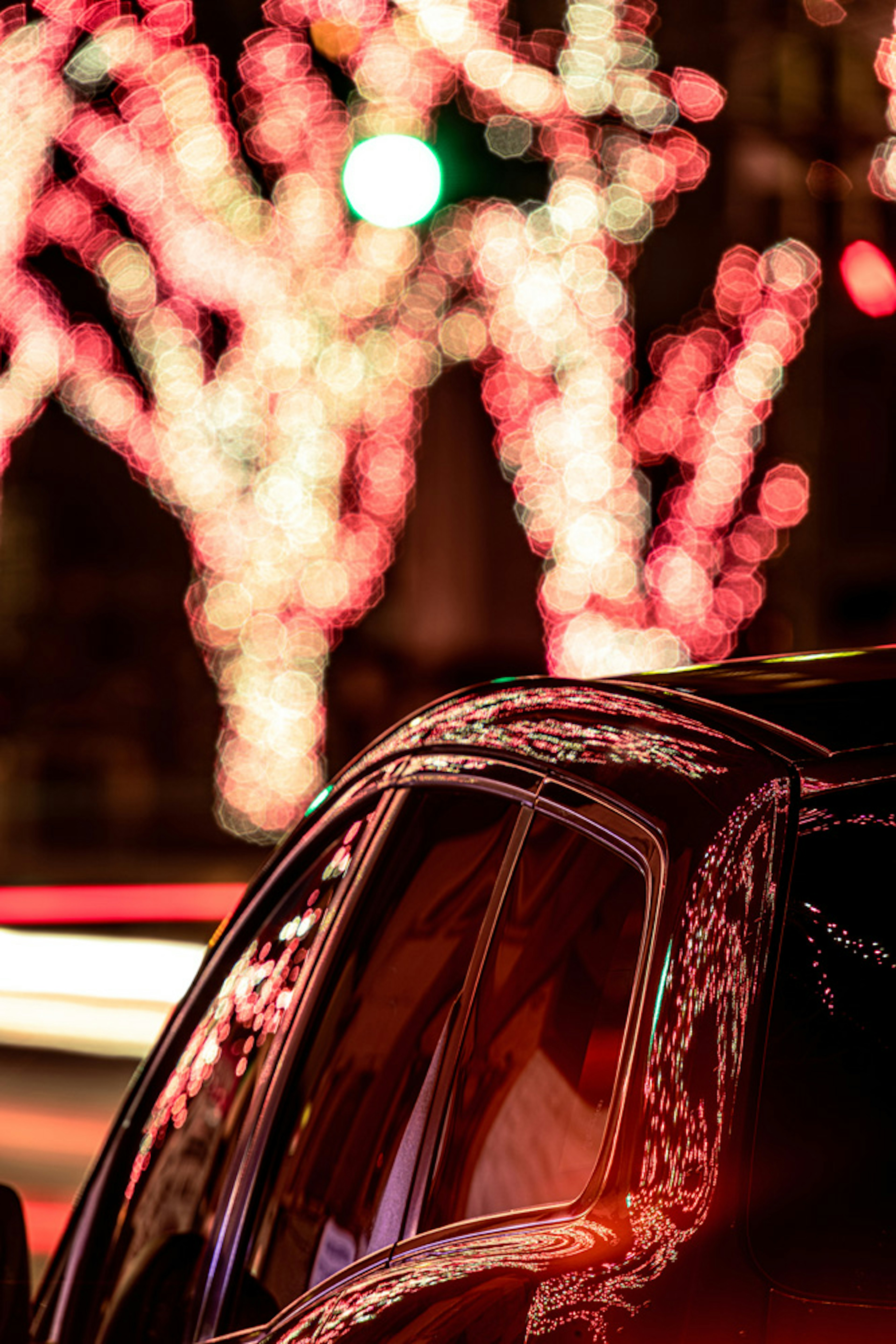 Vue latérale d'une voiture avec des lumières colorées en arrière-plan la nuit