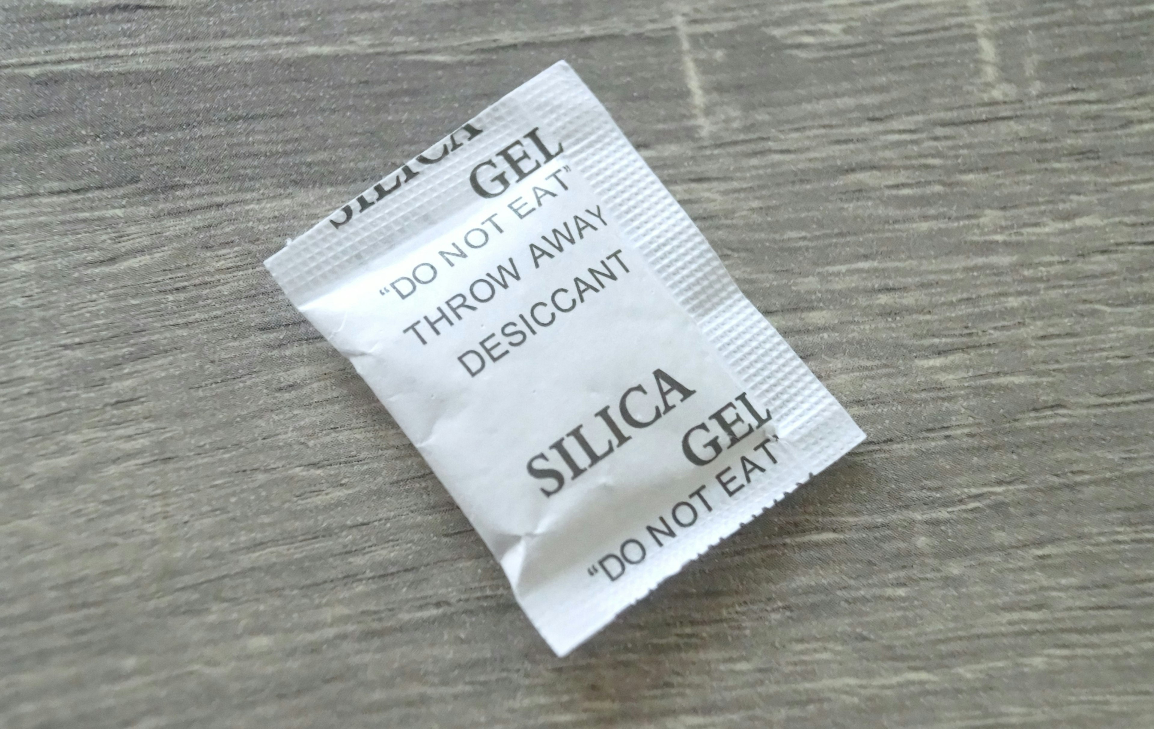 Silica gel packet lying on a wooden table