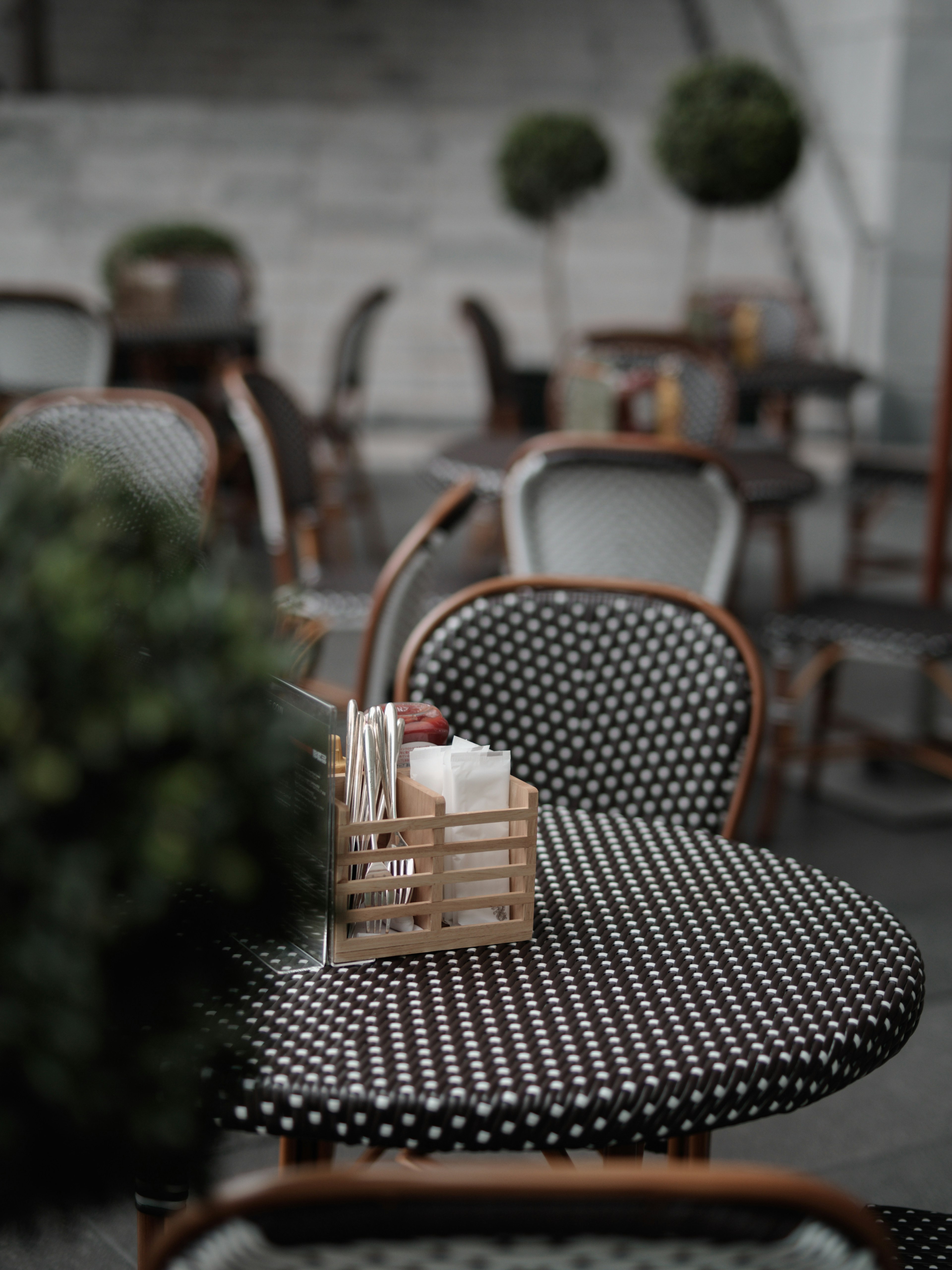 Configuración de café al aire libre con mesa de lunares y soporte de cubiertos de madera