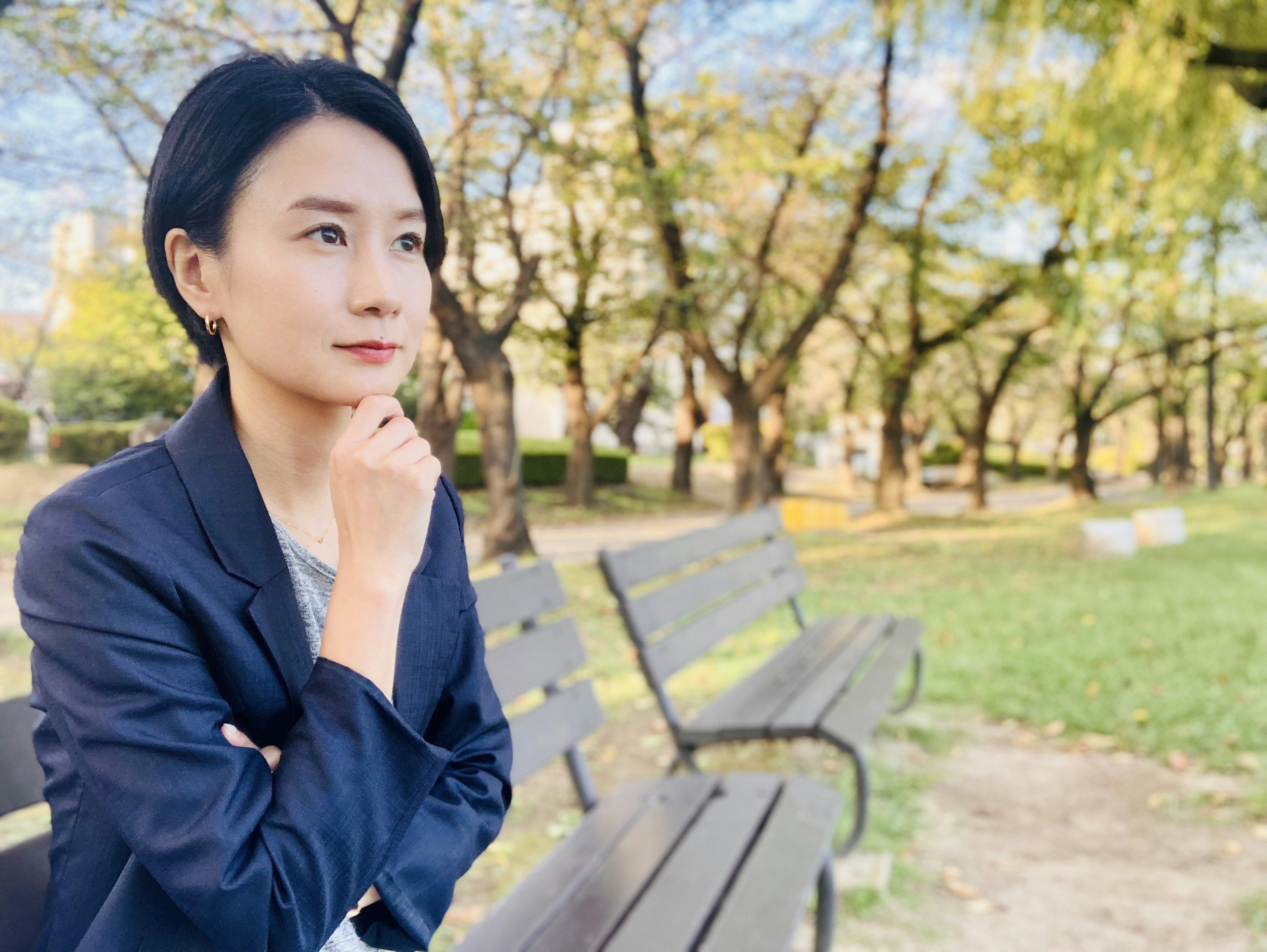 Image d'une femme assise sur un banc de parc en pleine réflexion