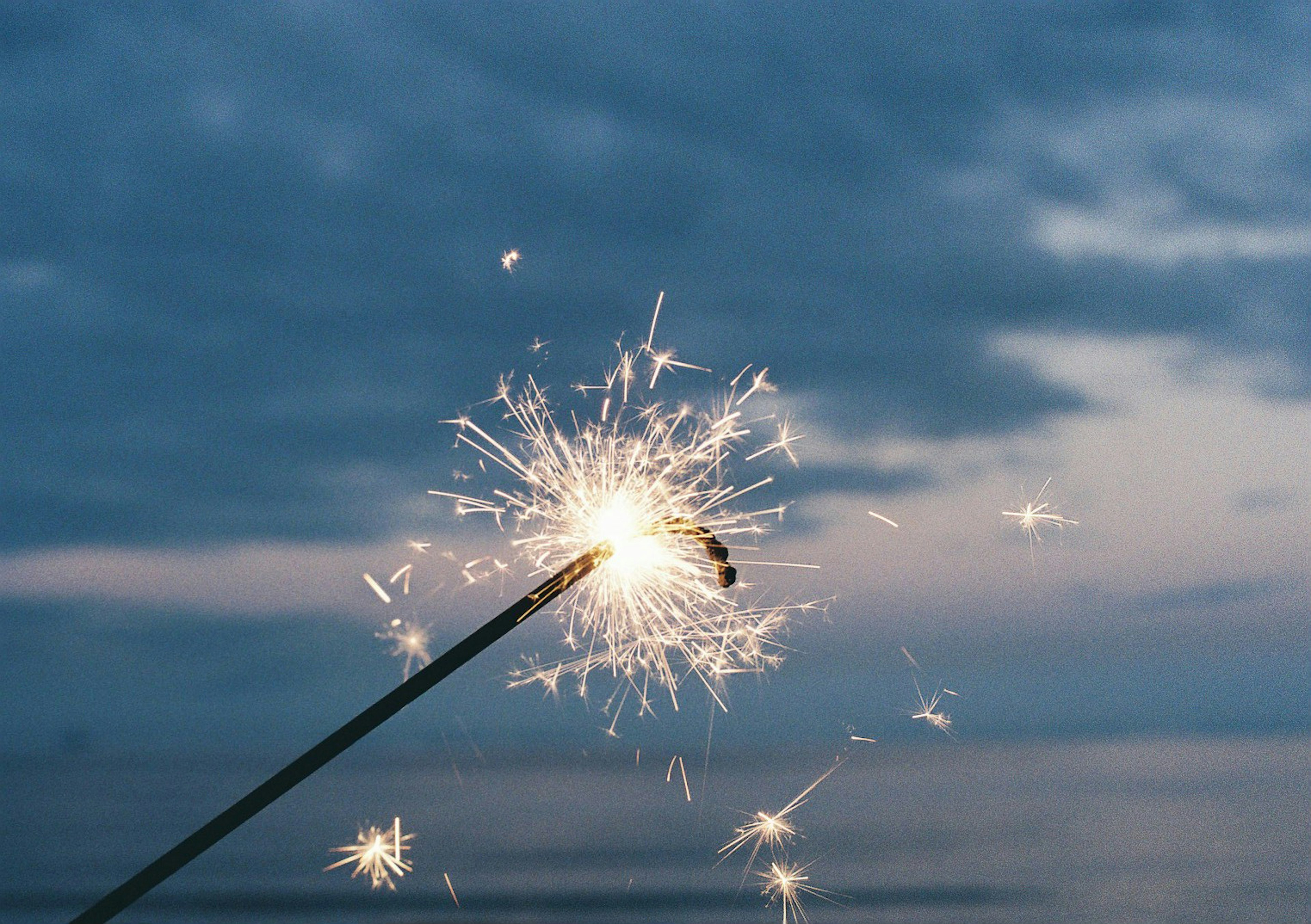 Sparkler glowing near the sea at twilight sky