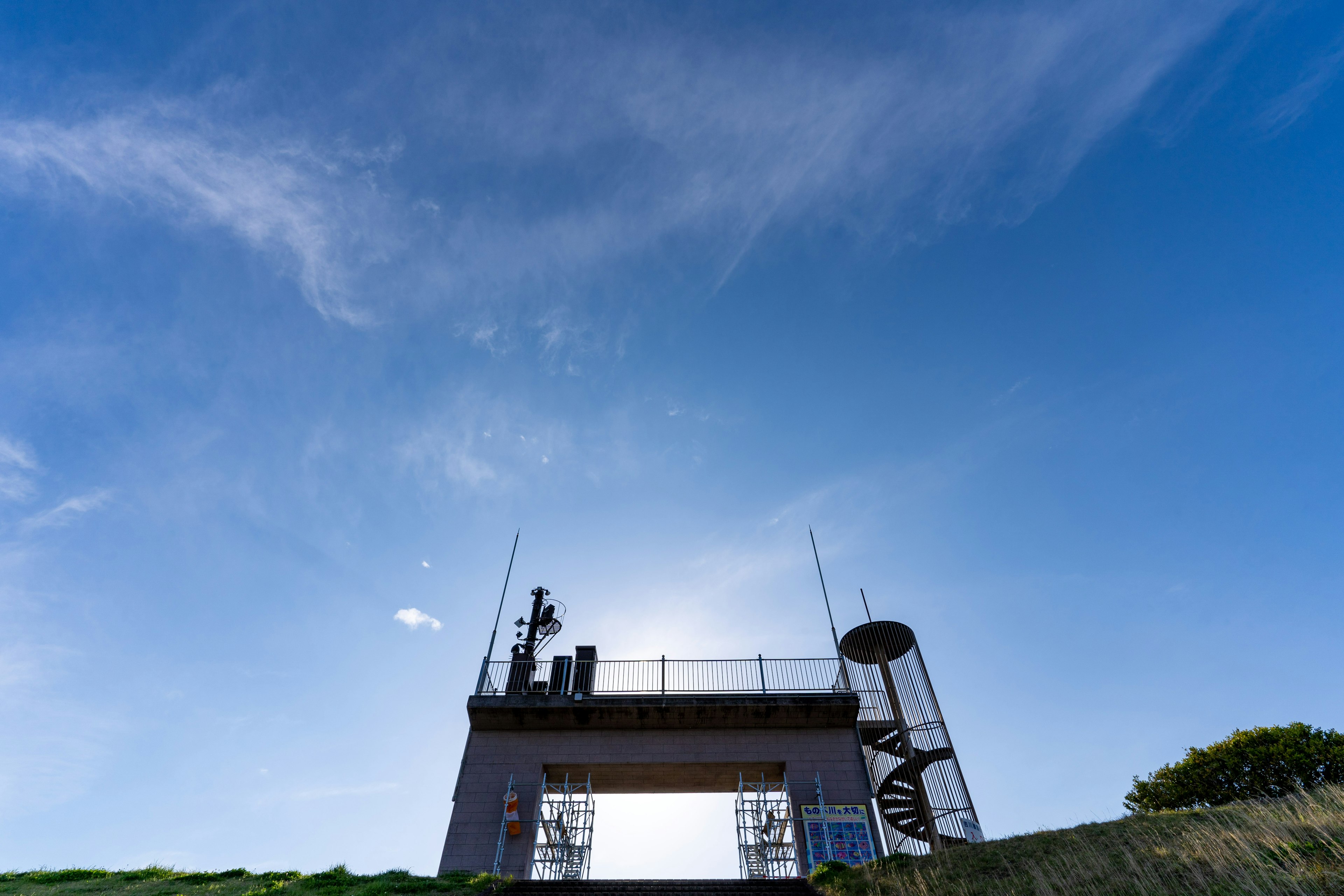 青空の下にある通信塔とその構造物