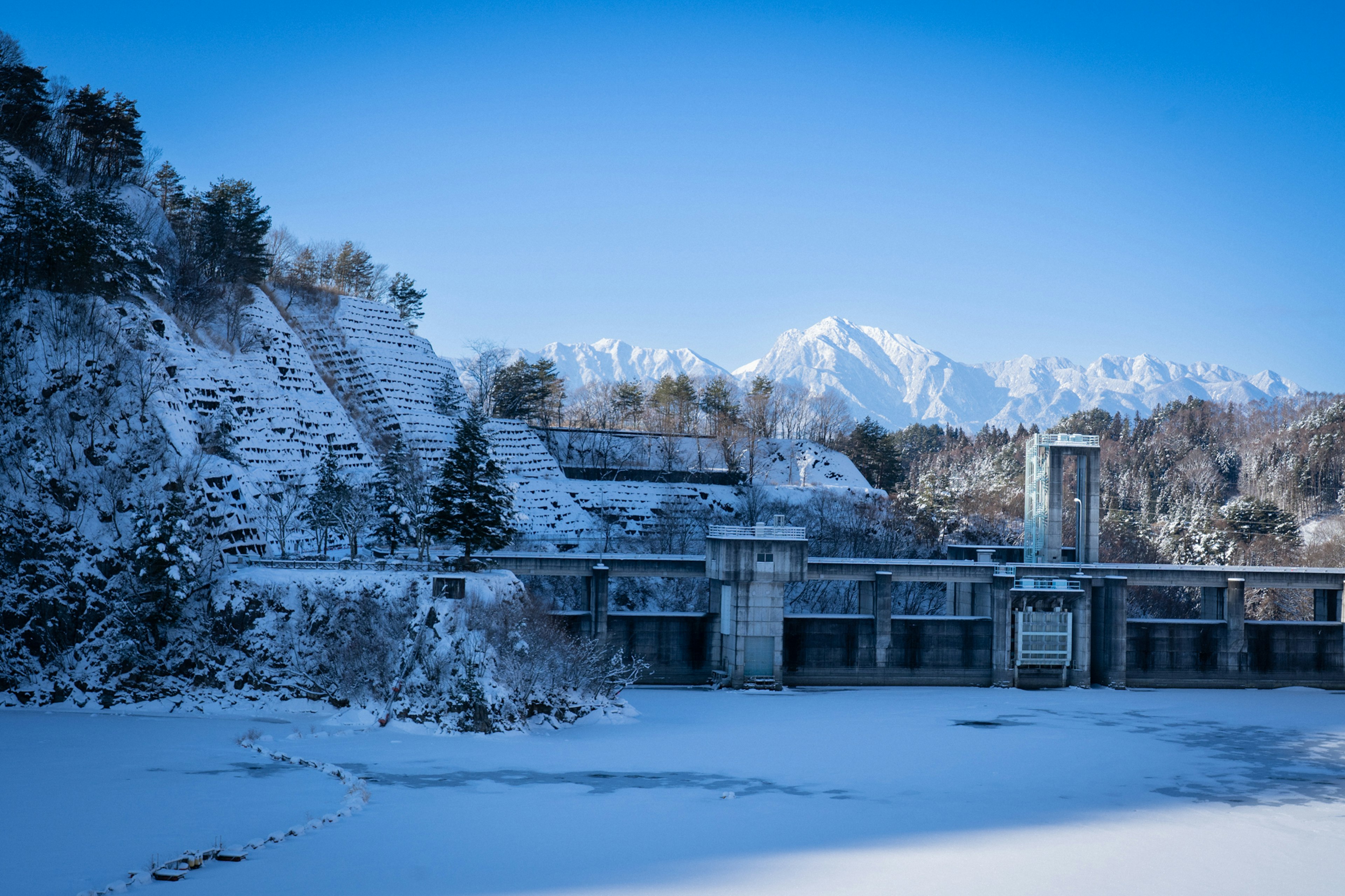 雪に覆われたダムと山々の風景