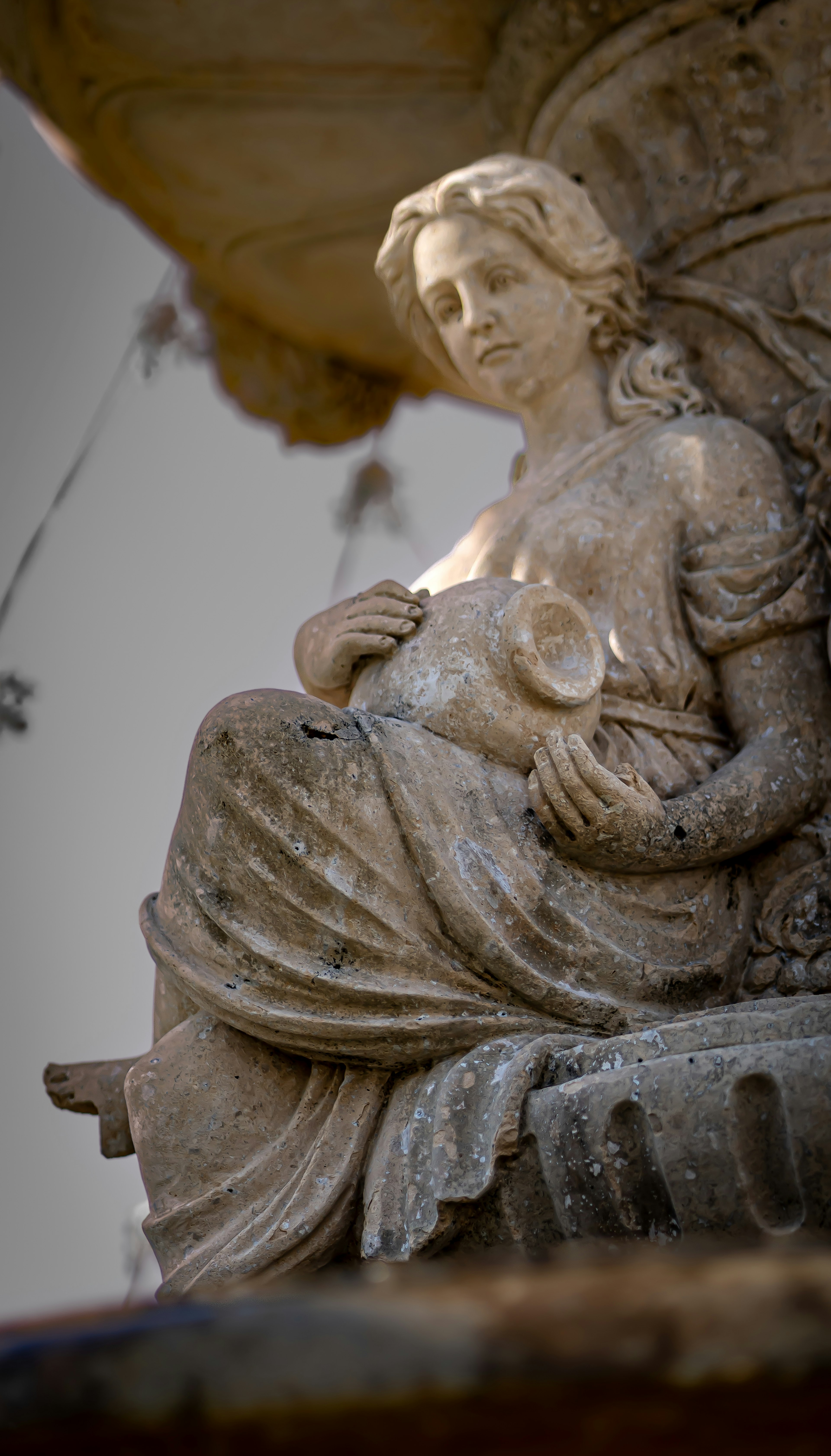 Sculpted female figure holding a water pitcher as part of a fountain