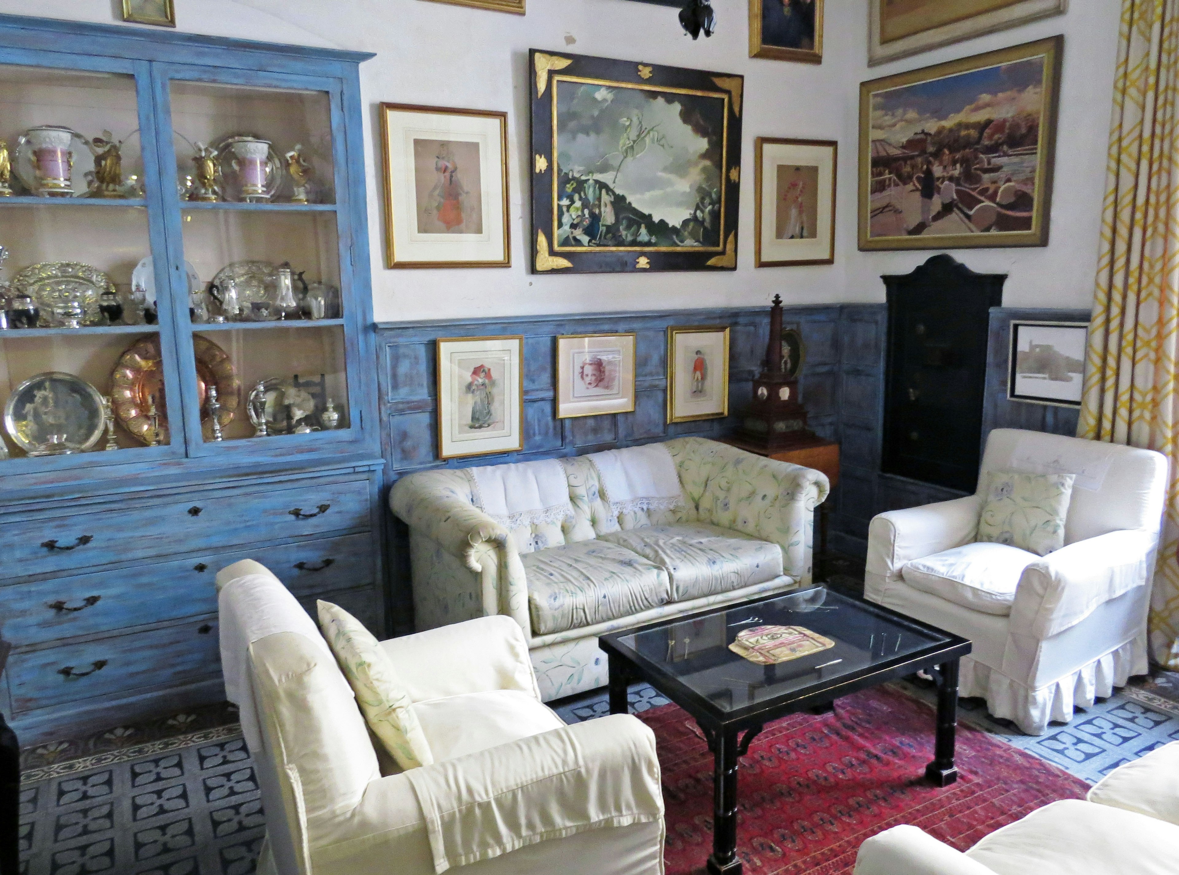 Living room interior featuring a blue cabinet and white sofas