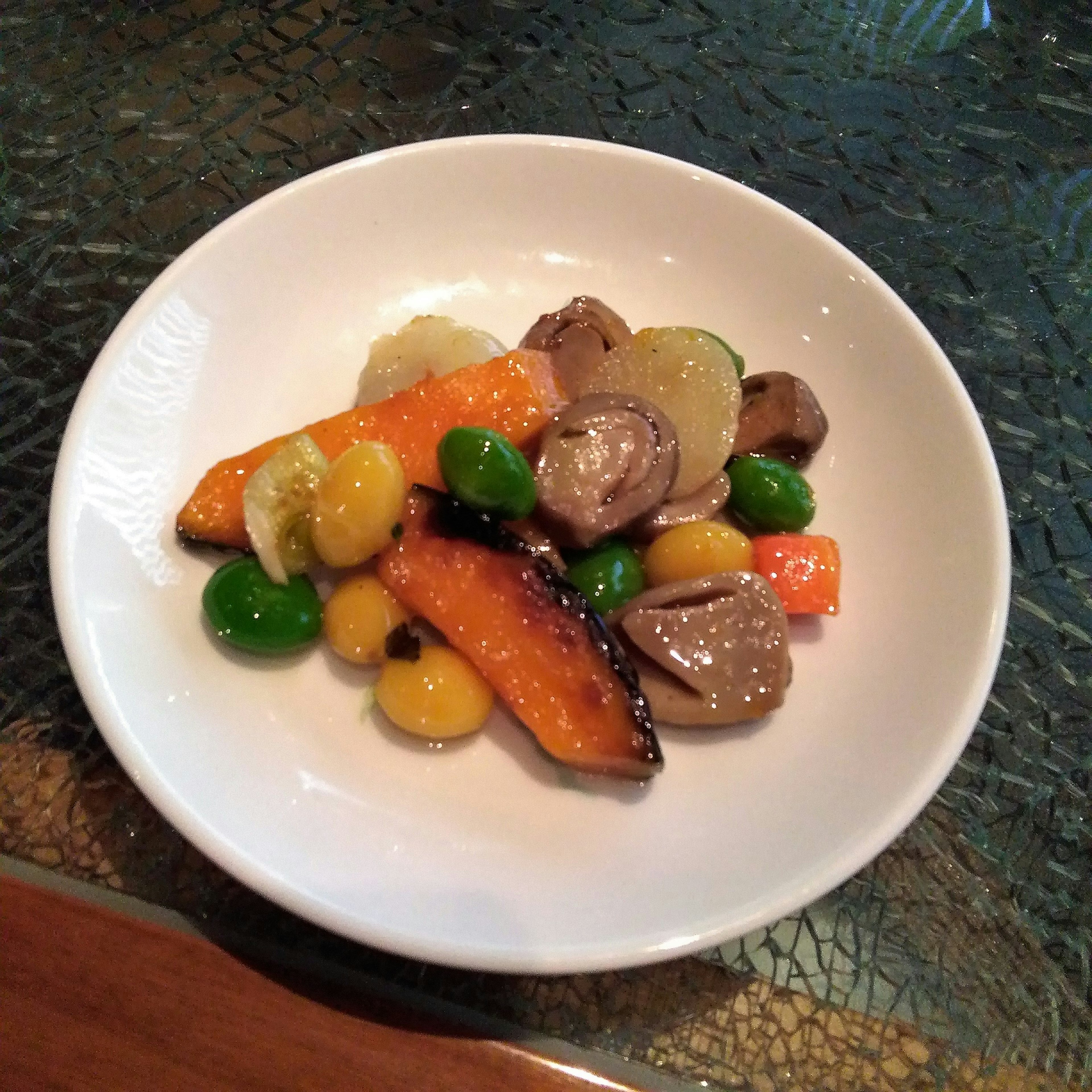 A beautifully arranged plate of Japanese cuisine featuring pumpkin and various beans