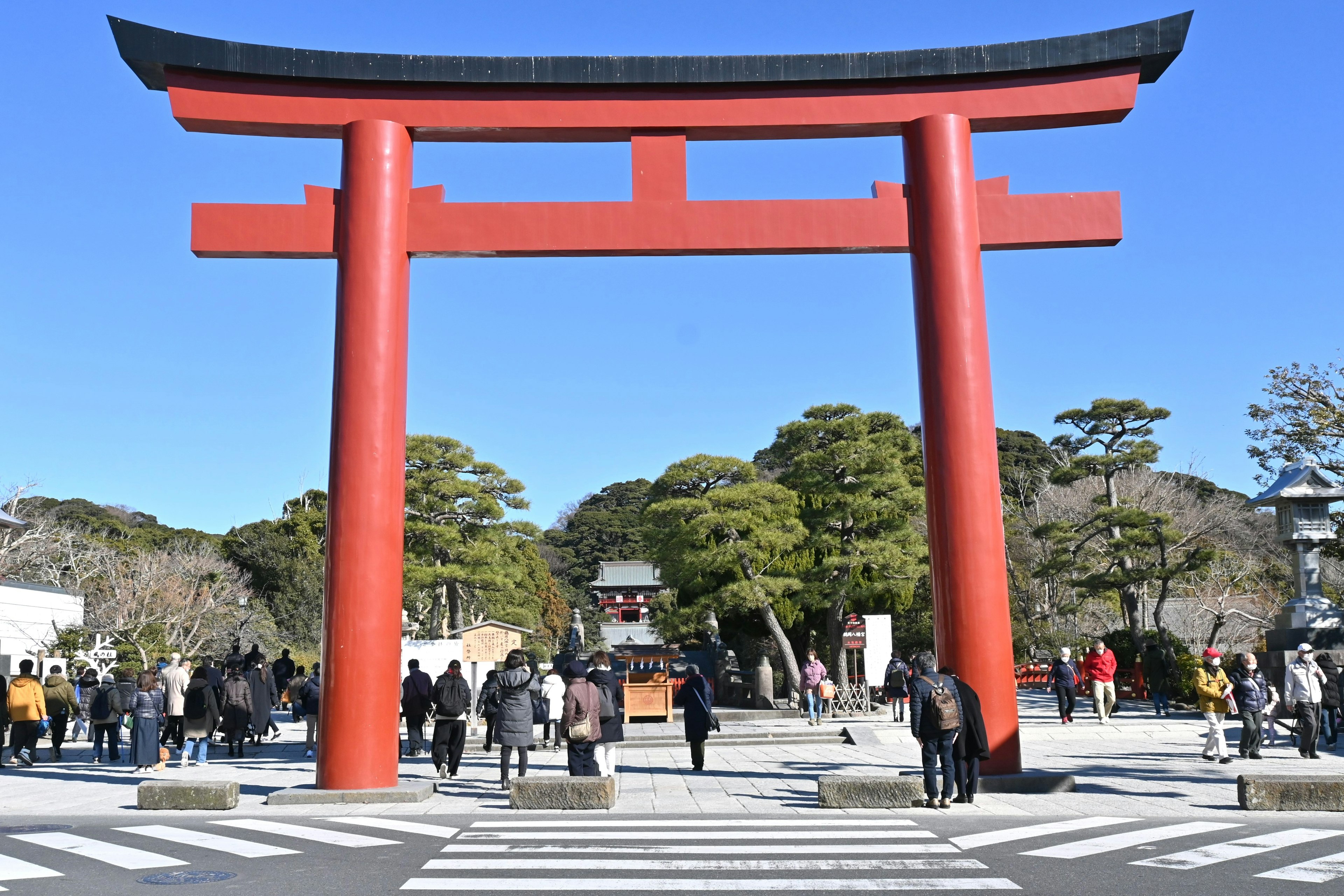 赤い鳥居の前にいる人々と青空の風景