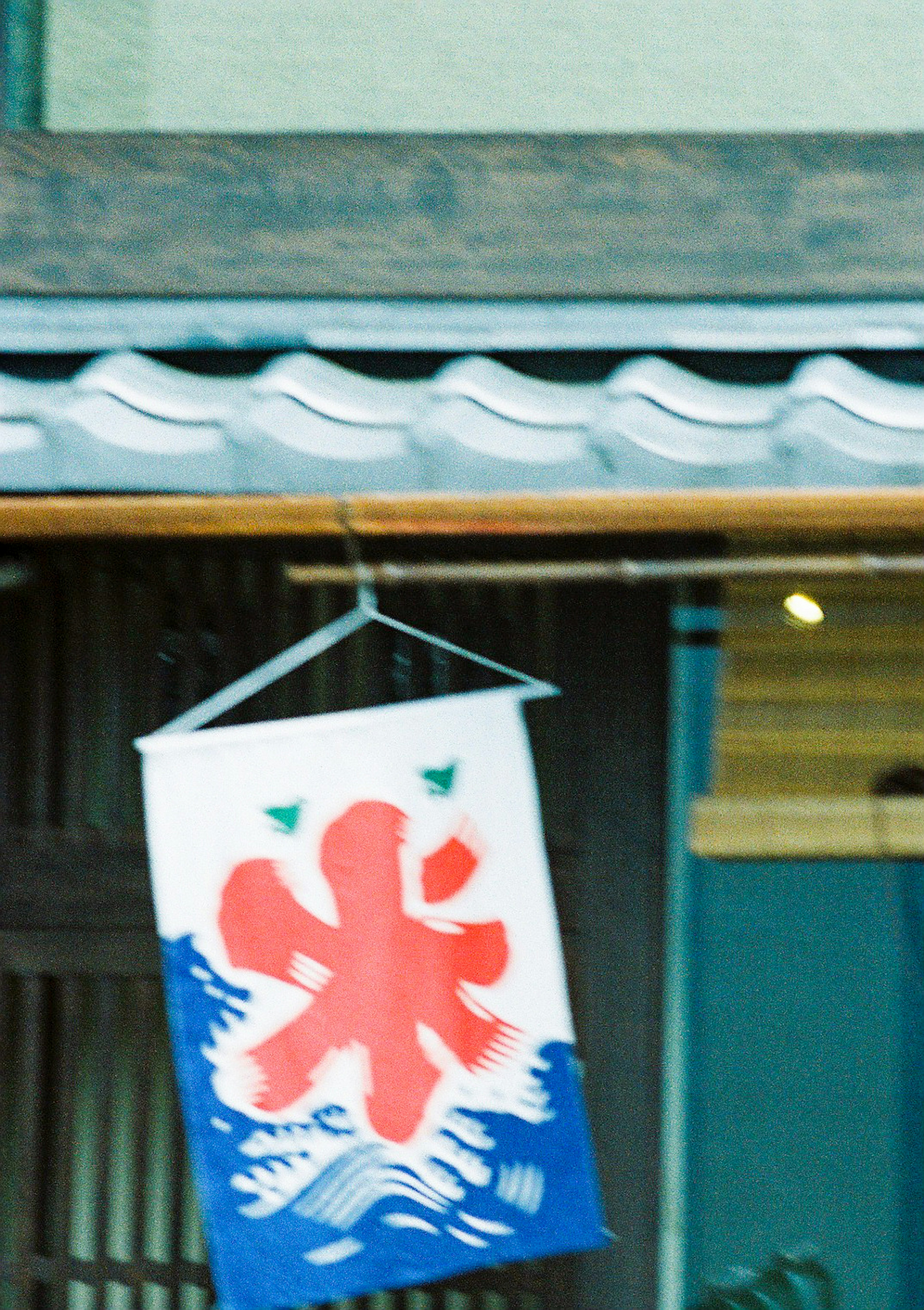 Noren featuring a red snowflake symbol and blue waves