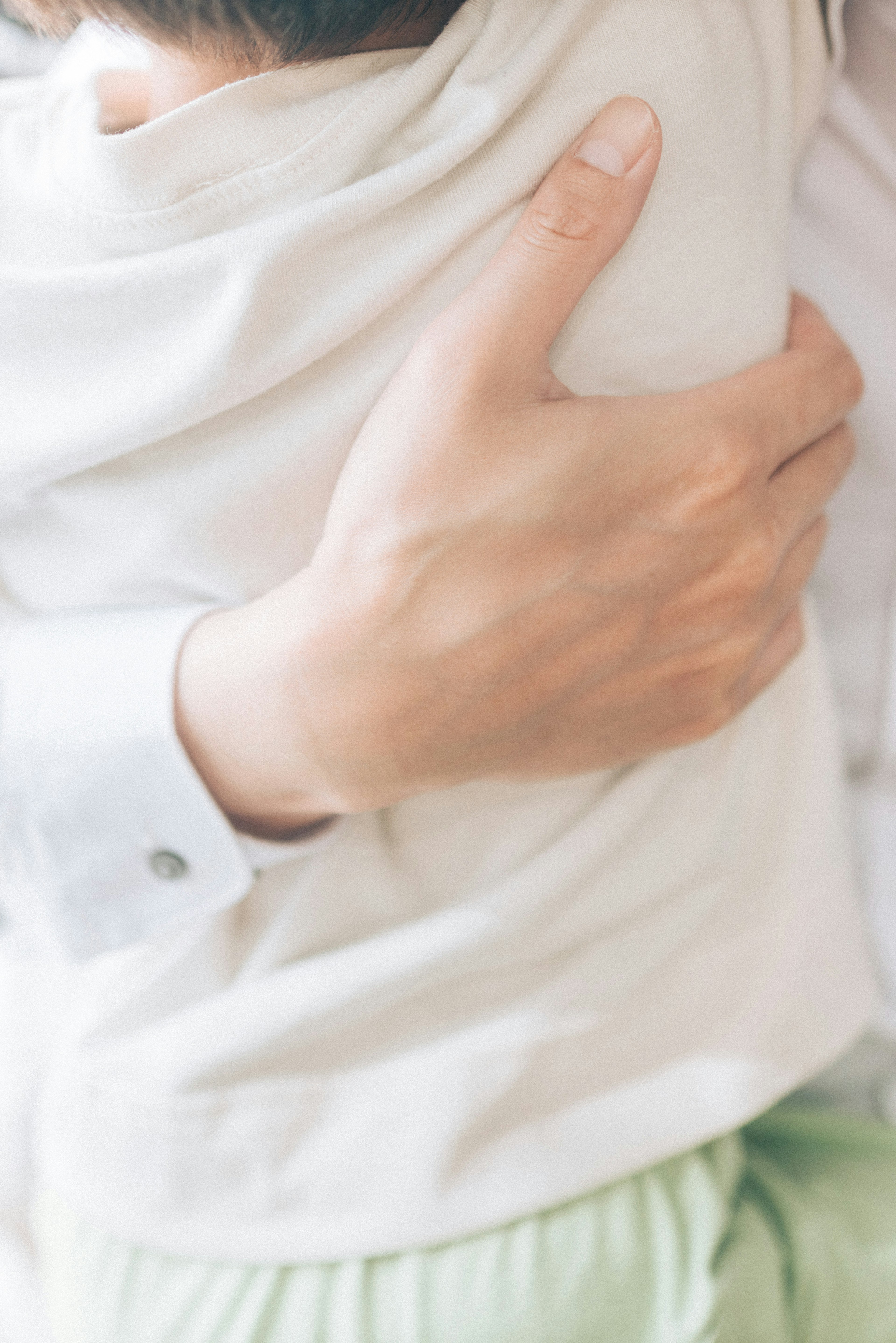 A parent's hand gently holding a child