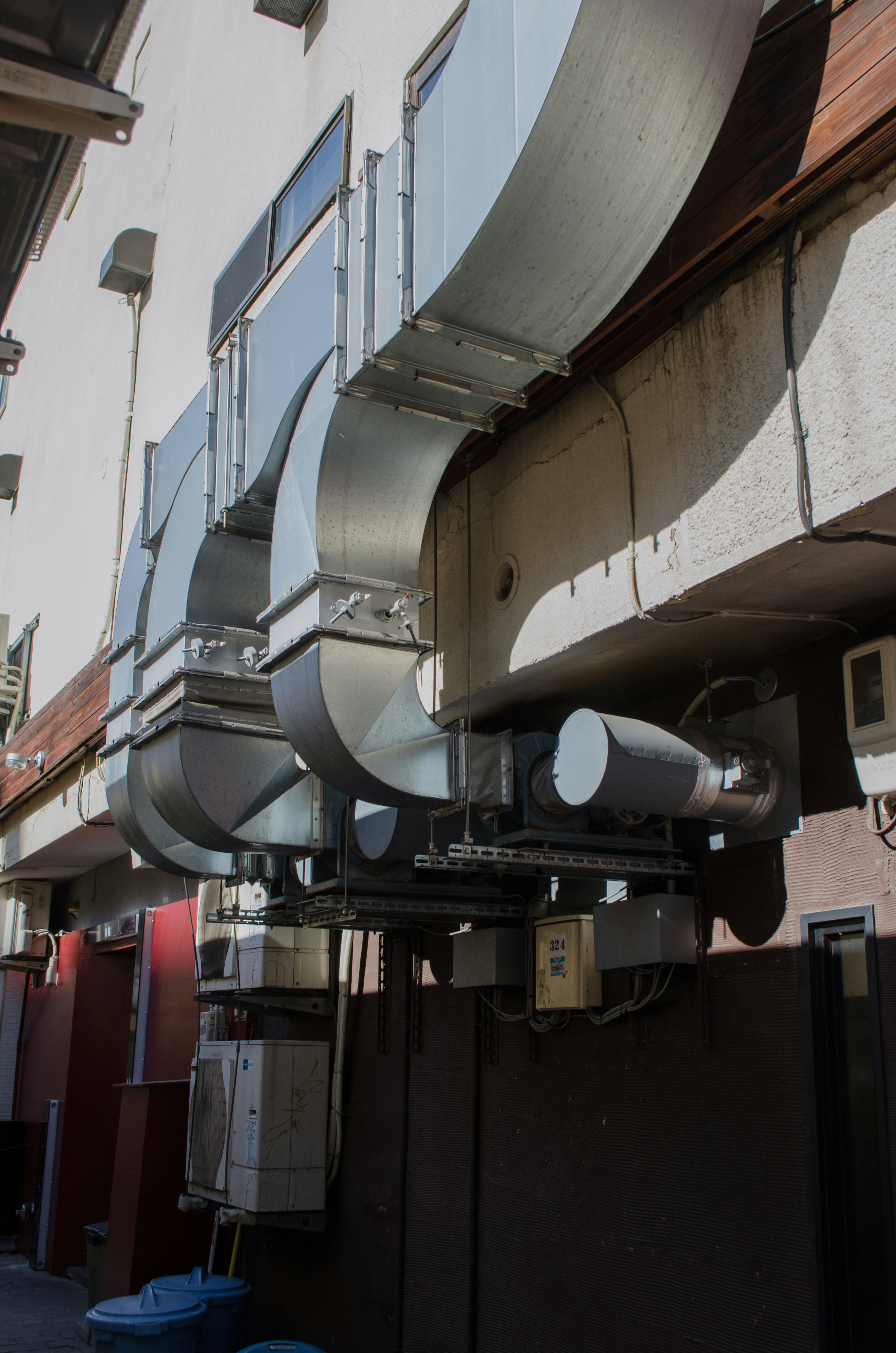 Image présentant des conduits en métal argenté fixés à la façade d'un bâtiment