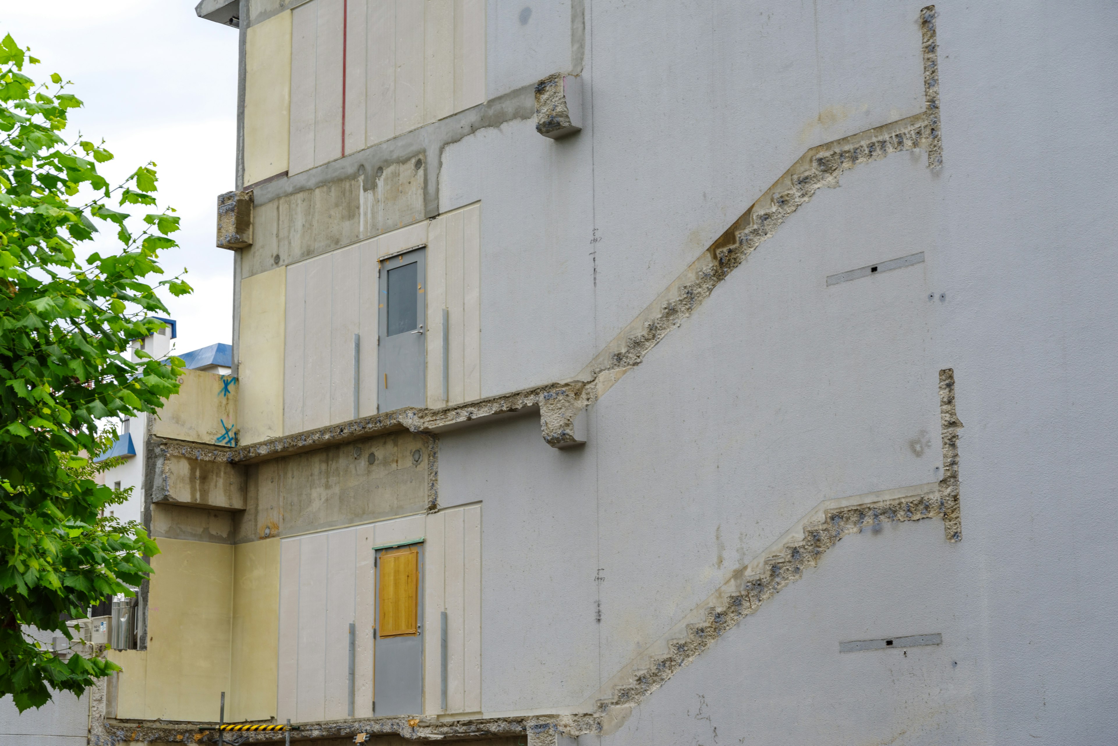 Edificio con pared blanca que presenta un contorno de escalera y una ventana