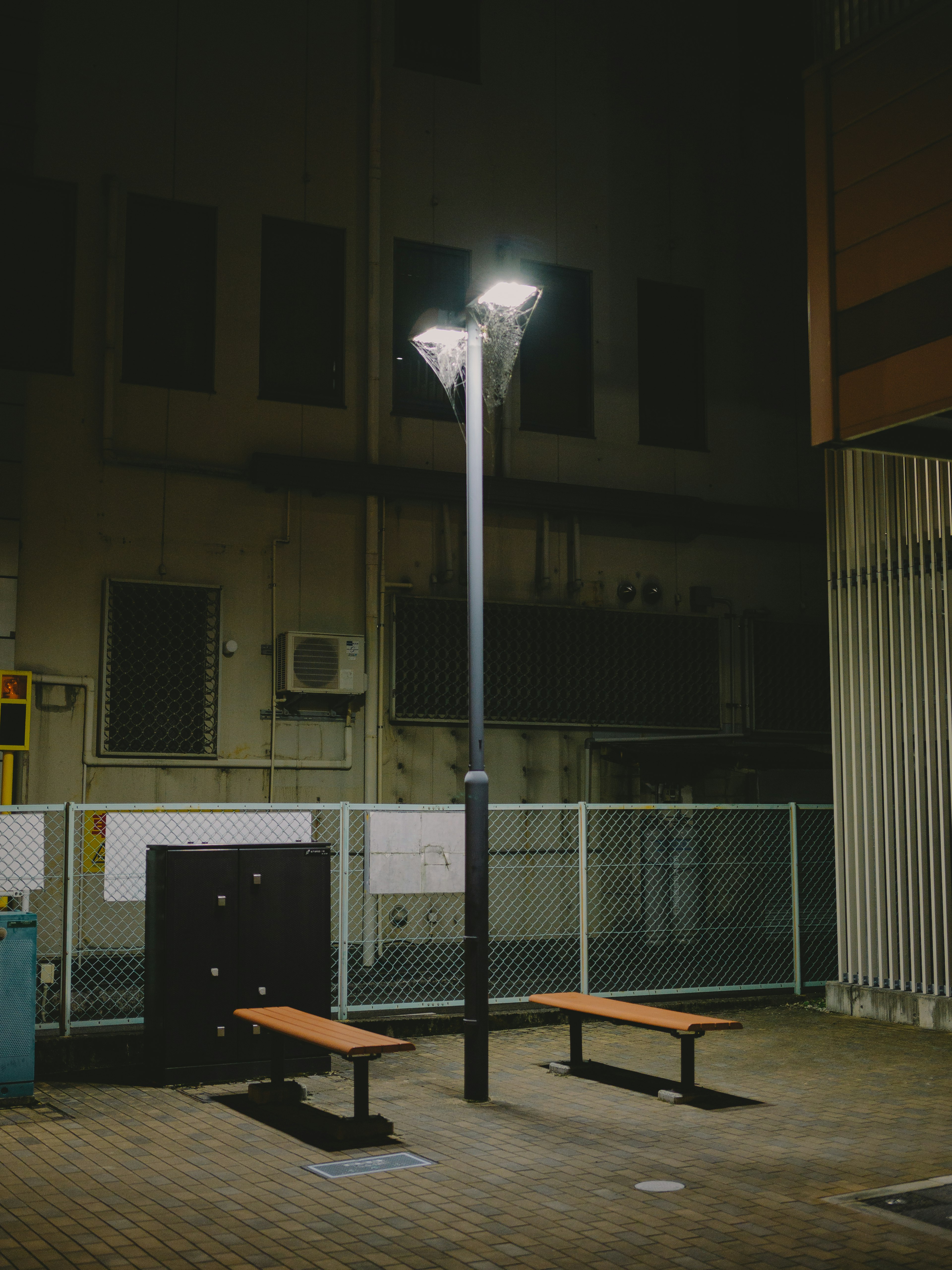 夜の街角にある街灯とベンチのある風景