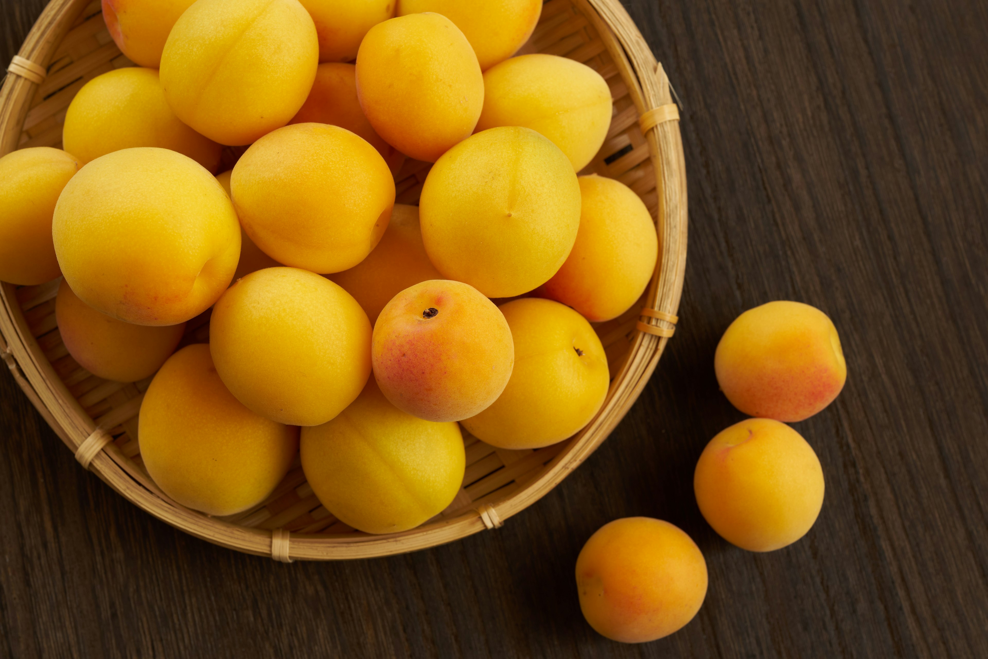 Fresh yellow peaches in a woven basket