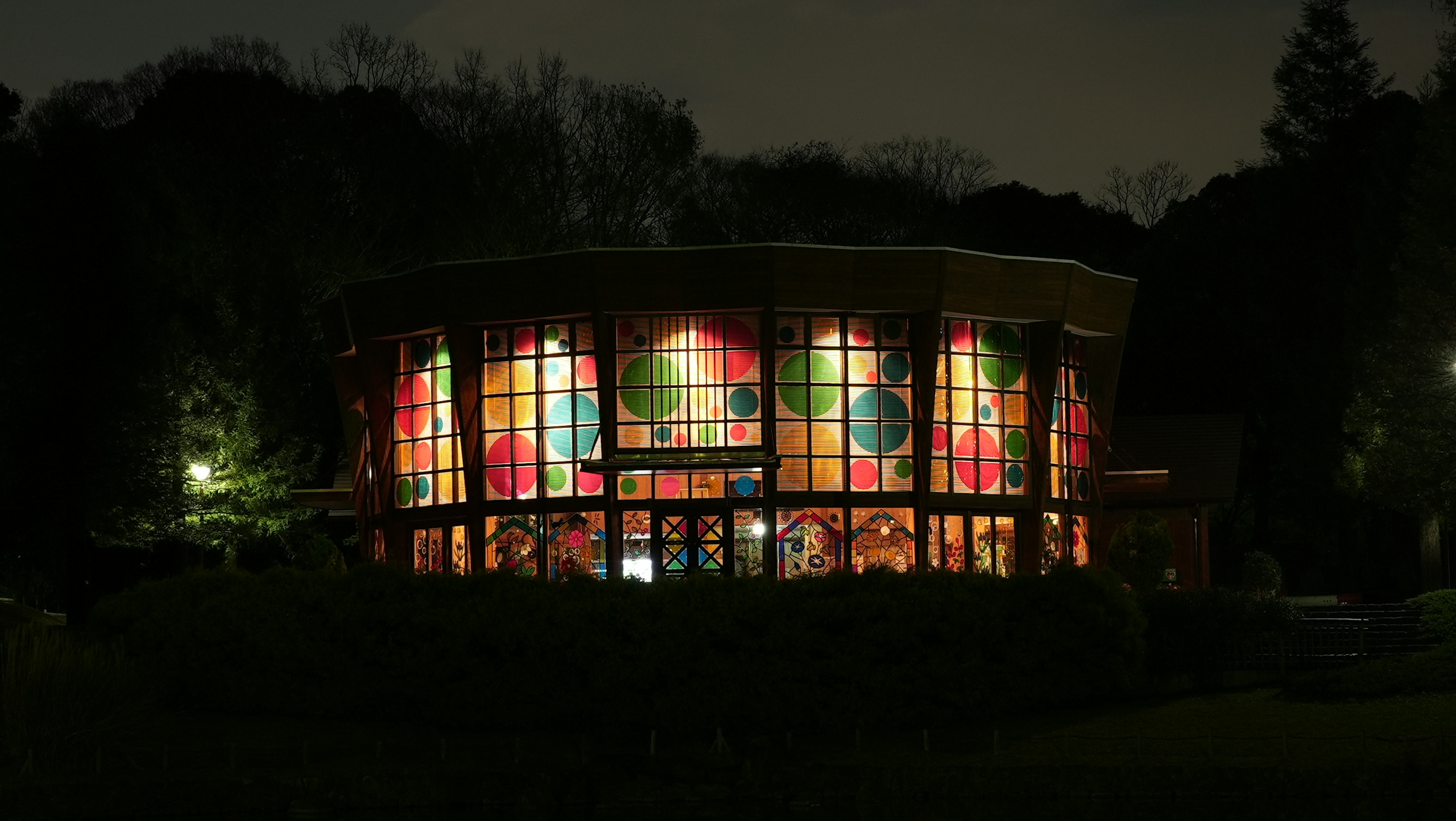 夜の公園にあるカラフルなステンドグラスの建物