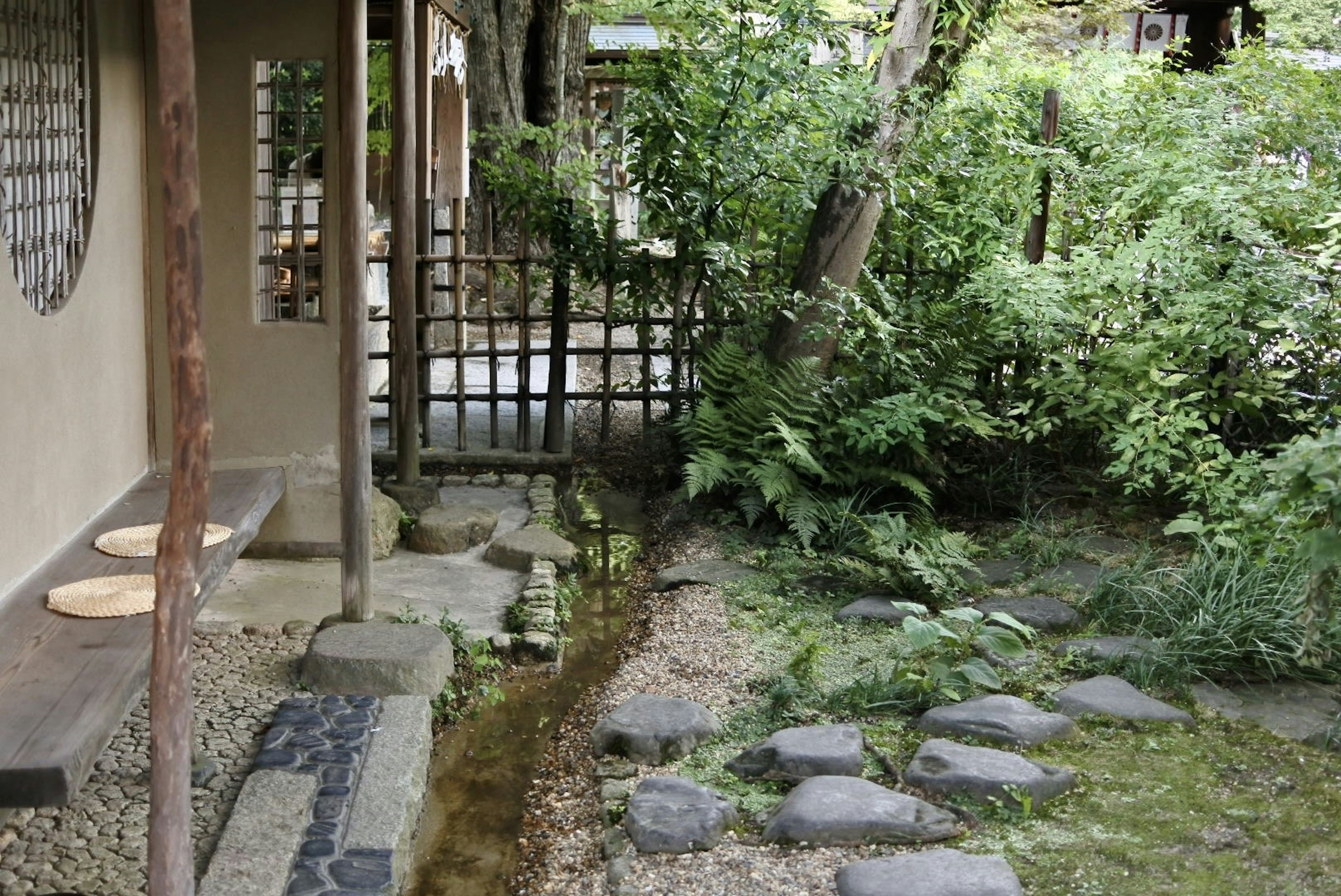 Pemandangan tenang dengan taman Jepang tradisional dan bagian dari bangunan tua