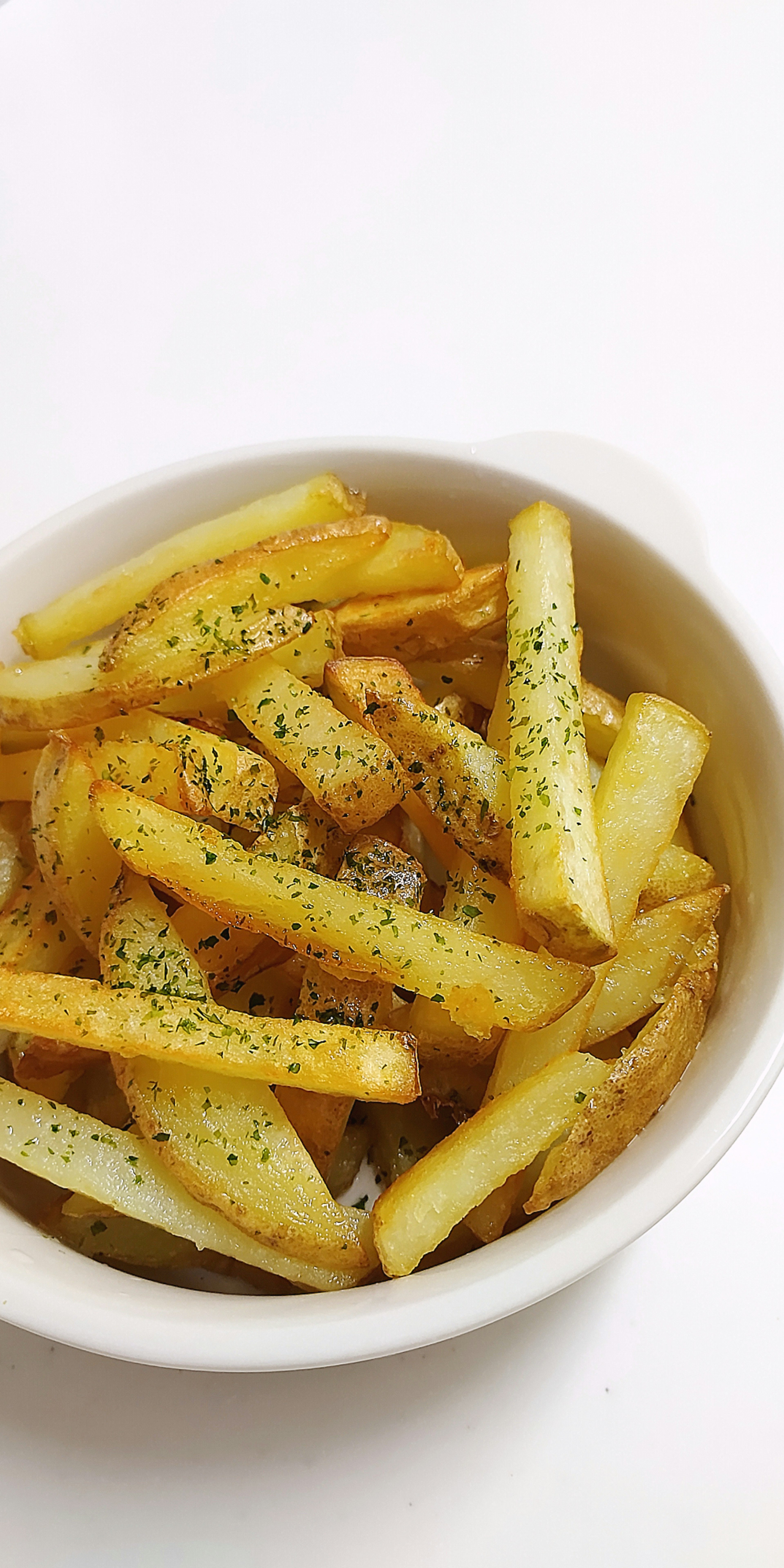 Knusprige Pommes Frites in einer weißen Schüssel serviert