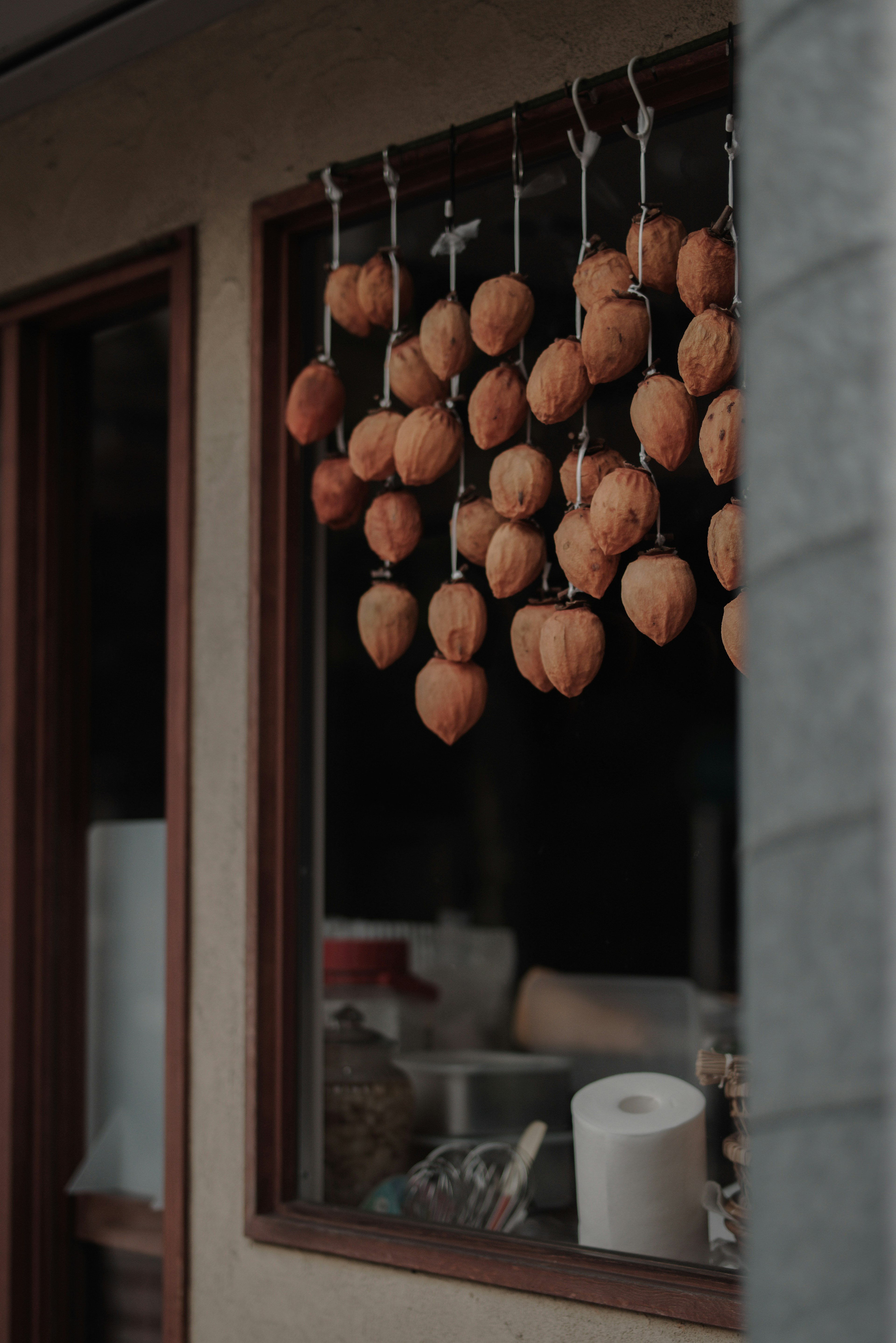 Dried persimmons hanging outside a window