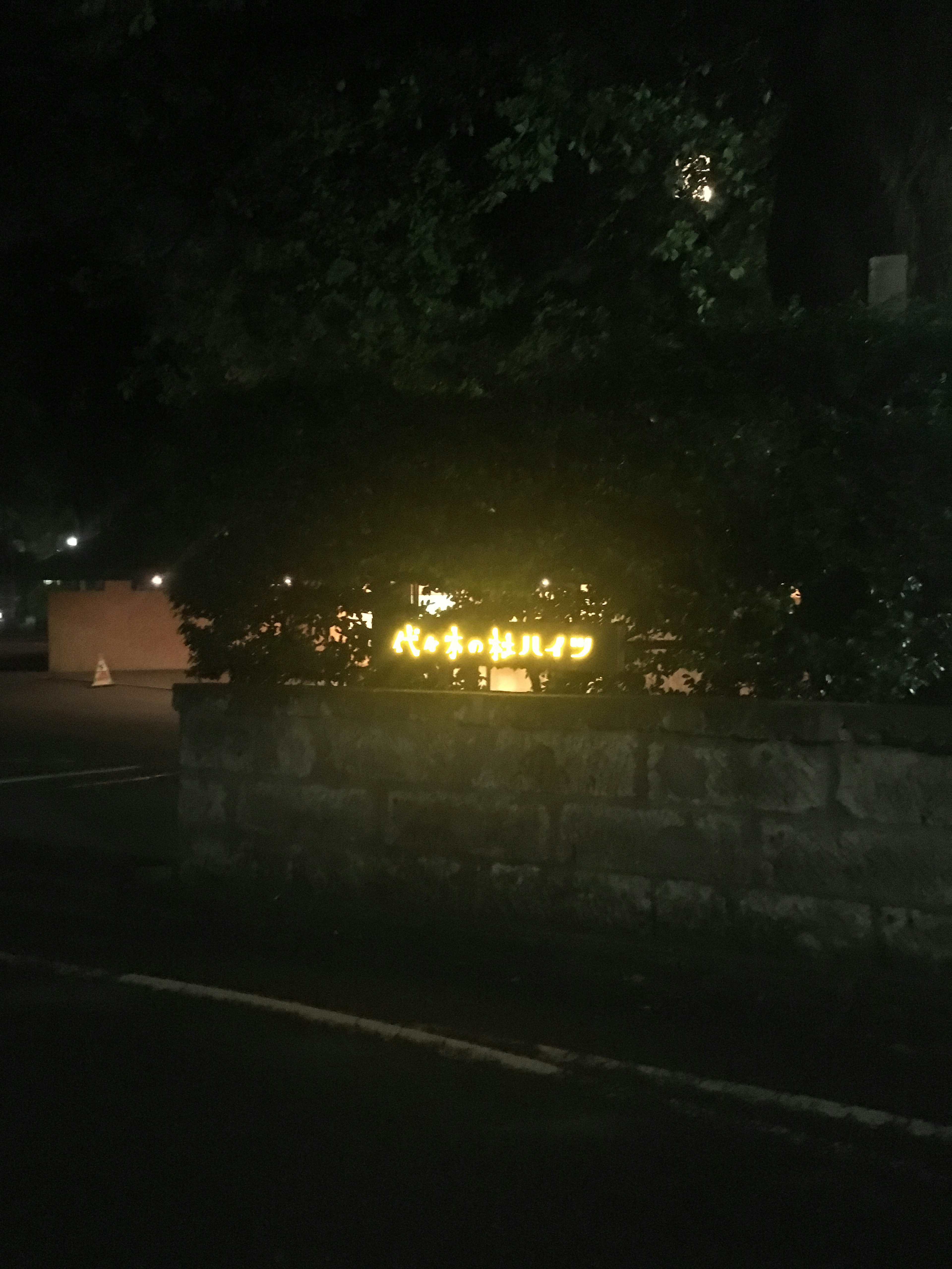 Panneau lumineux illuminé la nuit entouré de verdure