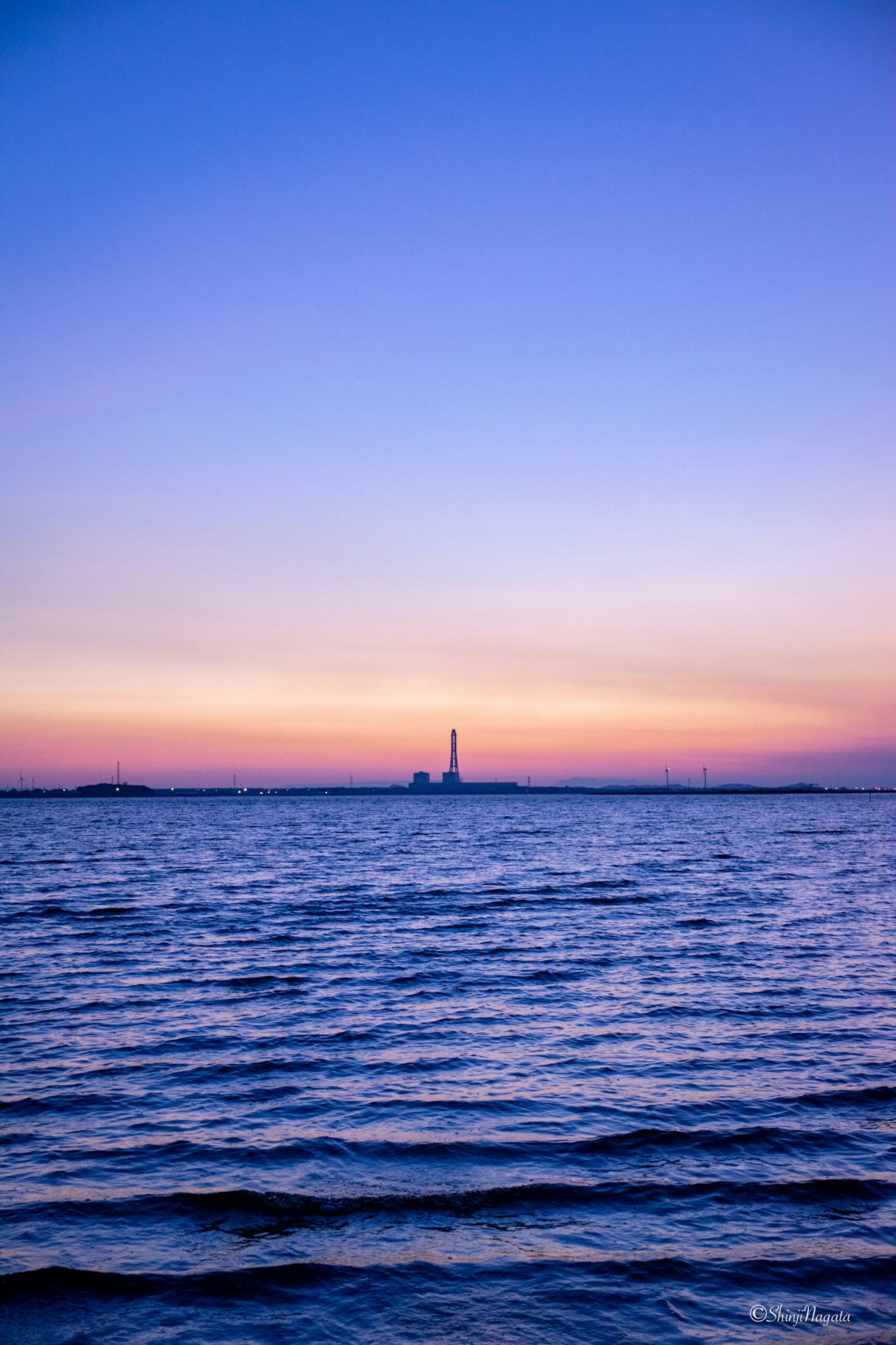 Torre que se eleva sobre el mar con un hermoso atardecer