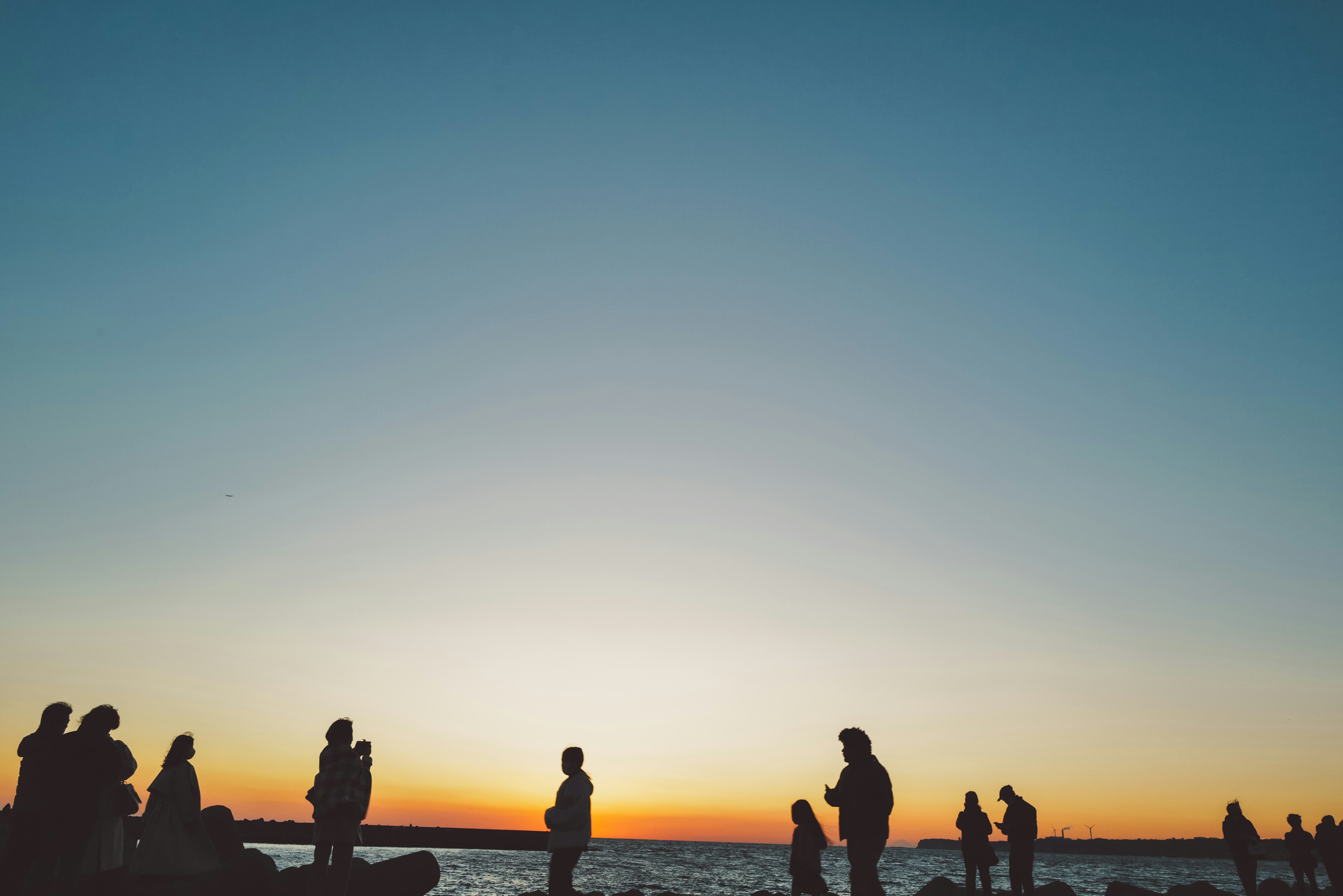 Silhouetten von Menschen am Strand während eines schönen Sonnenuntergangs