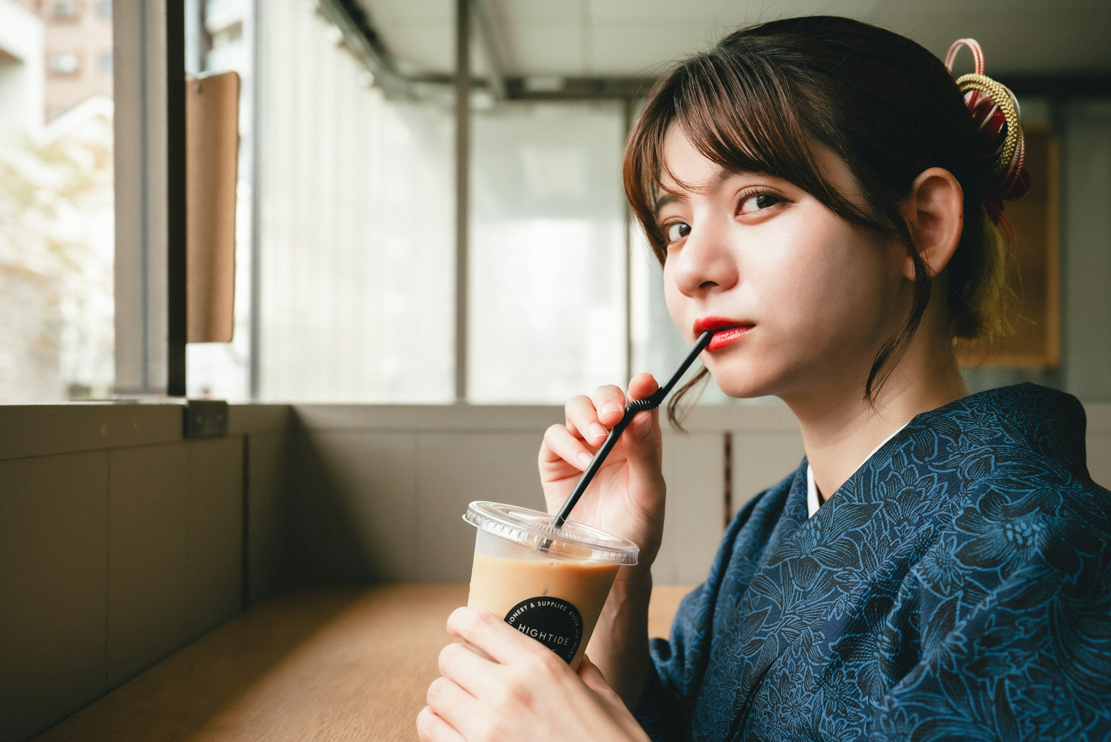 Frau, die in einem Café einen Eiskaffee trinkt