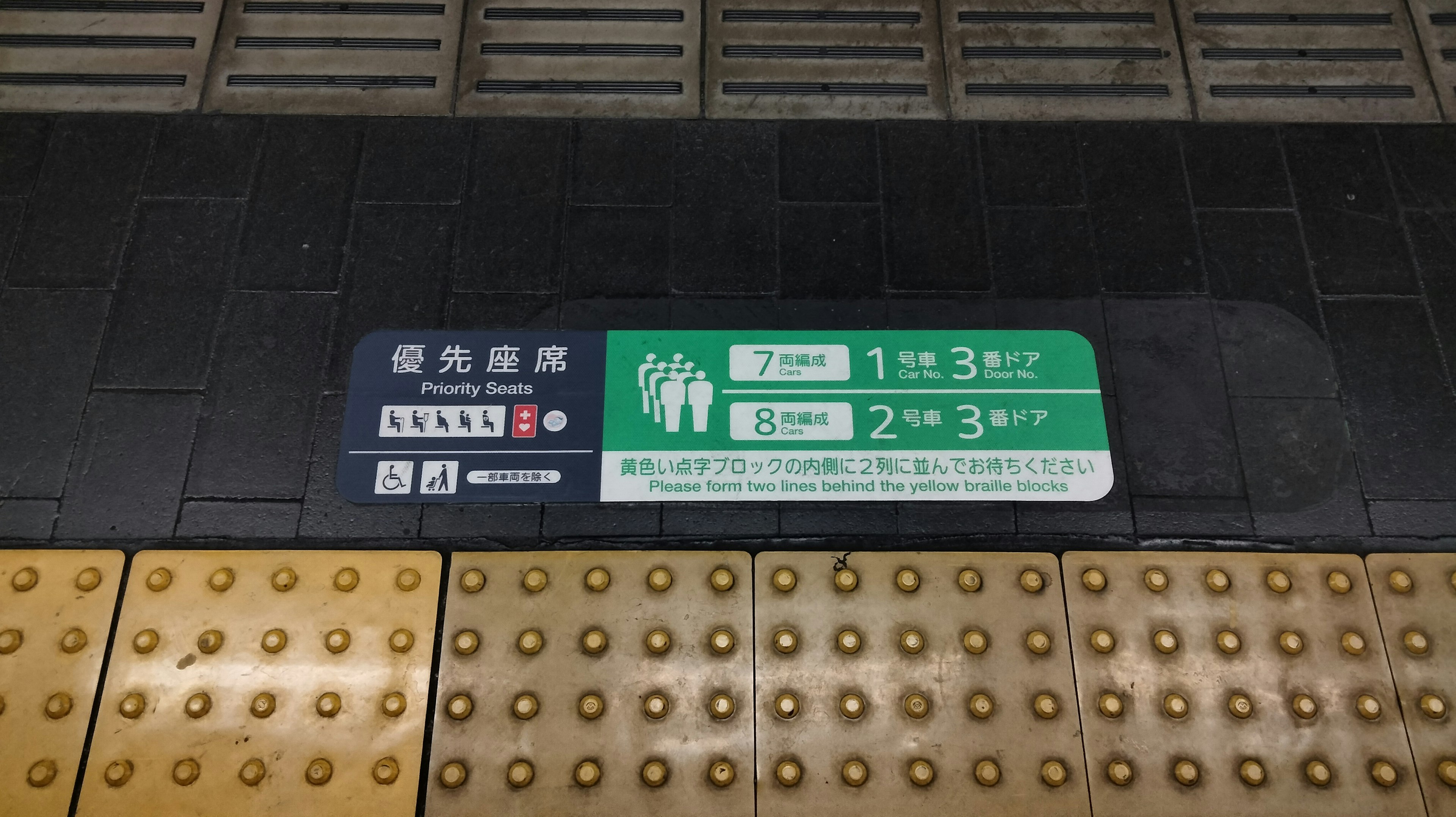 Station platform guidance sign with safety instructions for standing near the tracks