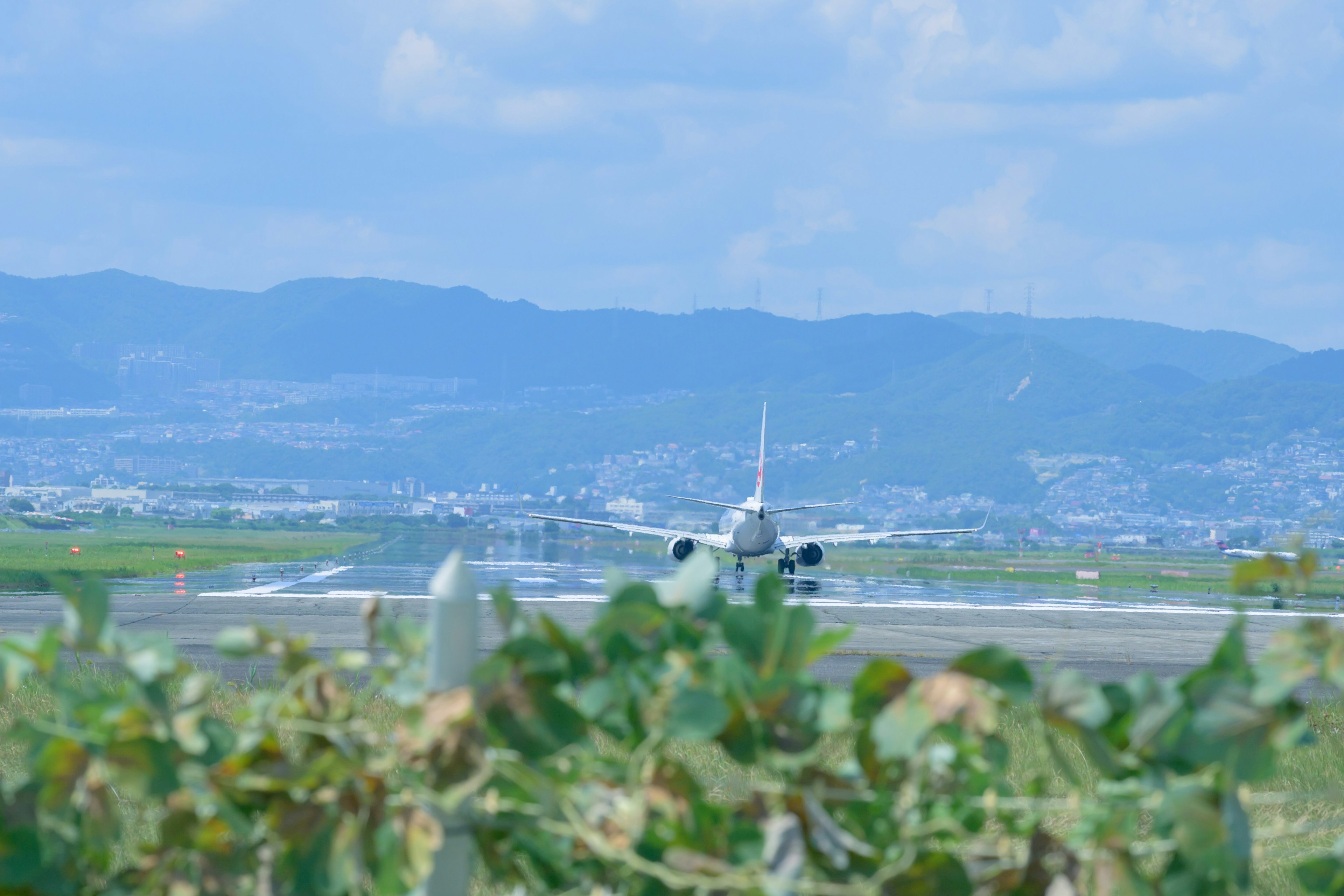 空港の滑走路に向かう飛行機と青空