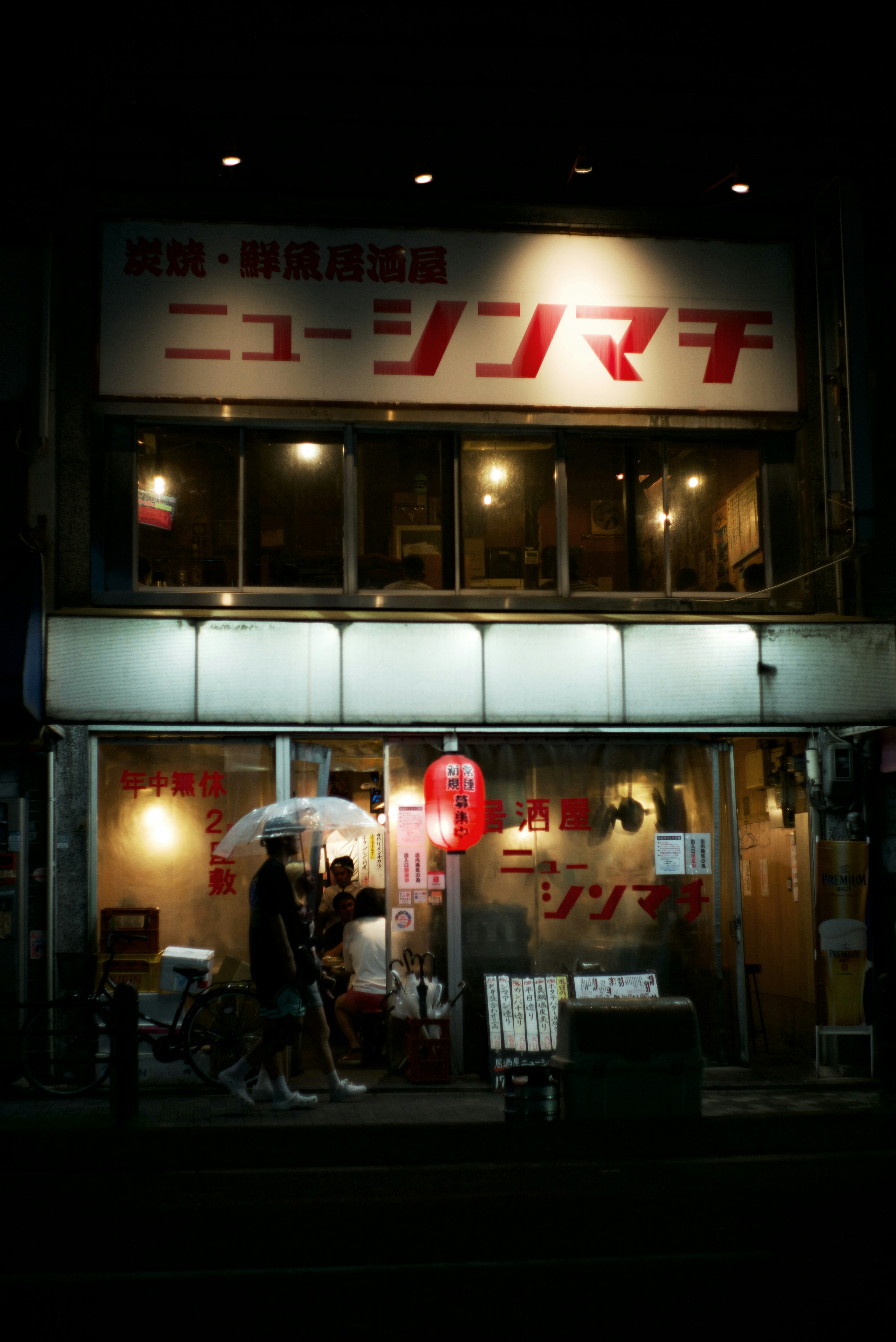 Magasin New Shinmachi la nuit avec des vitrines lumineuses