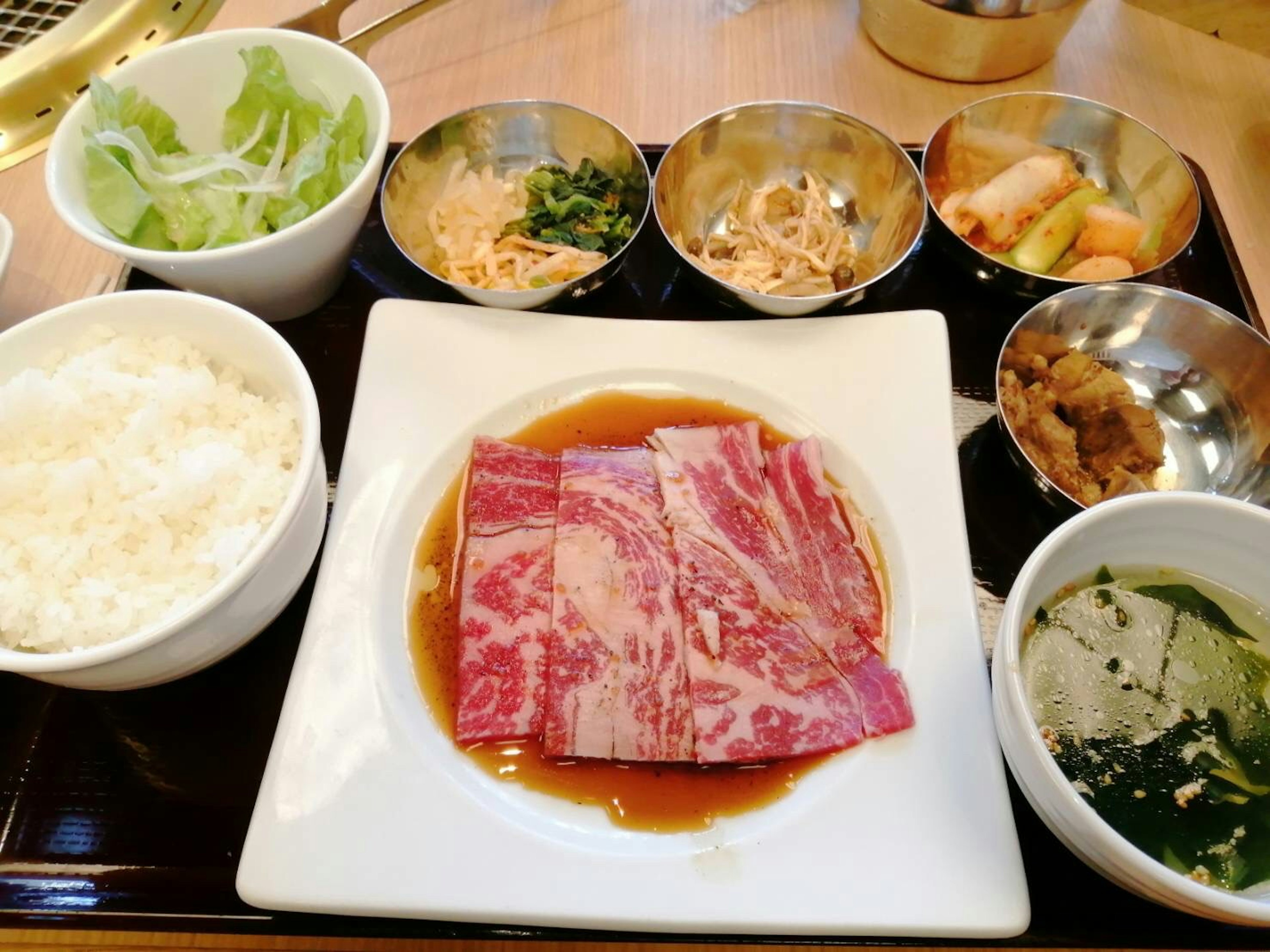 美味しそうな和食のプレート　生の肉とご飯　副菜が並ぶ