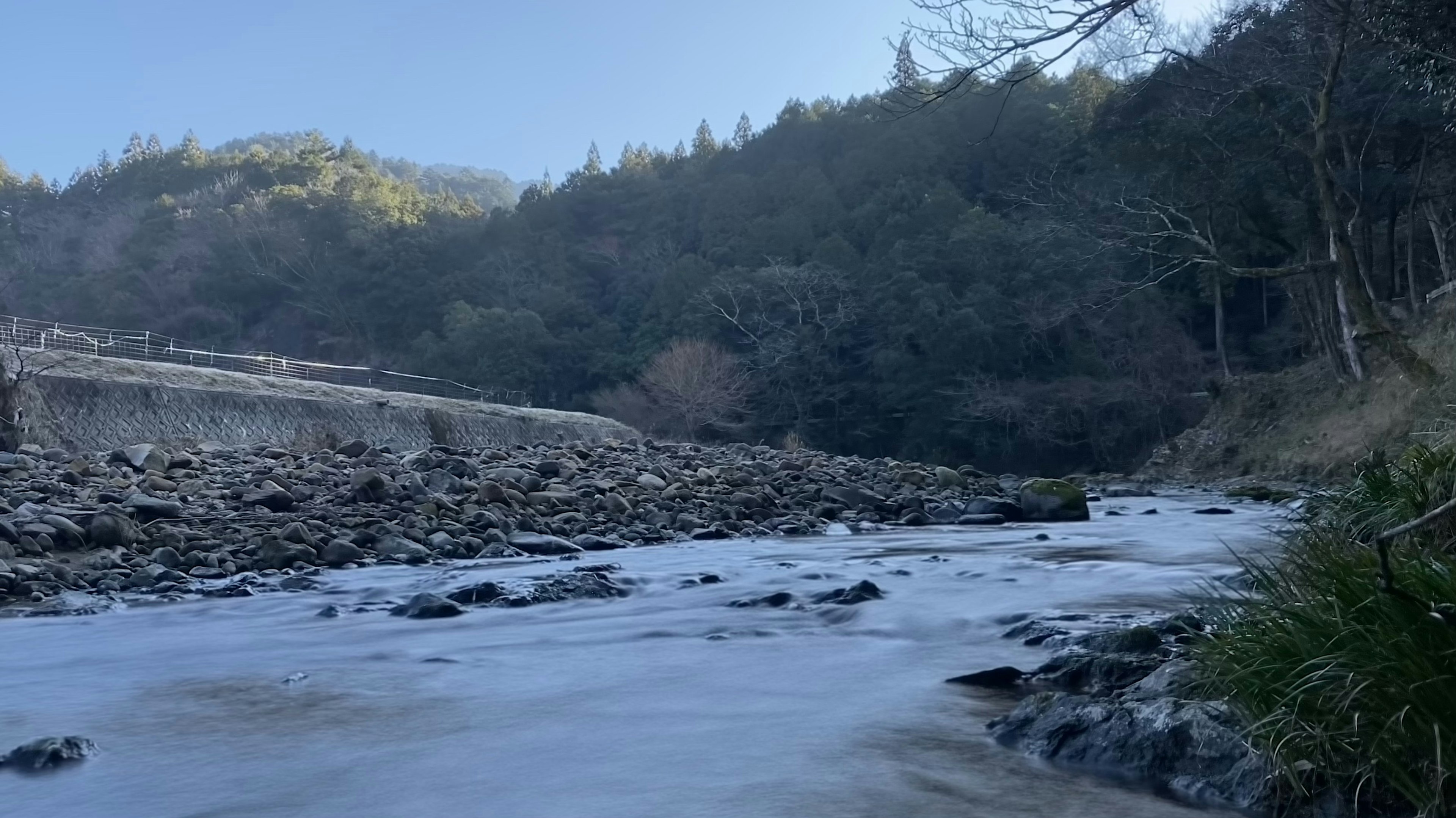 부드럽게 흐르는 강과 주변의 무성한 산들