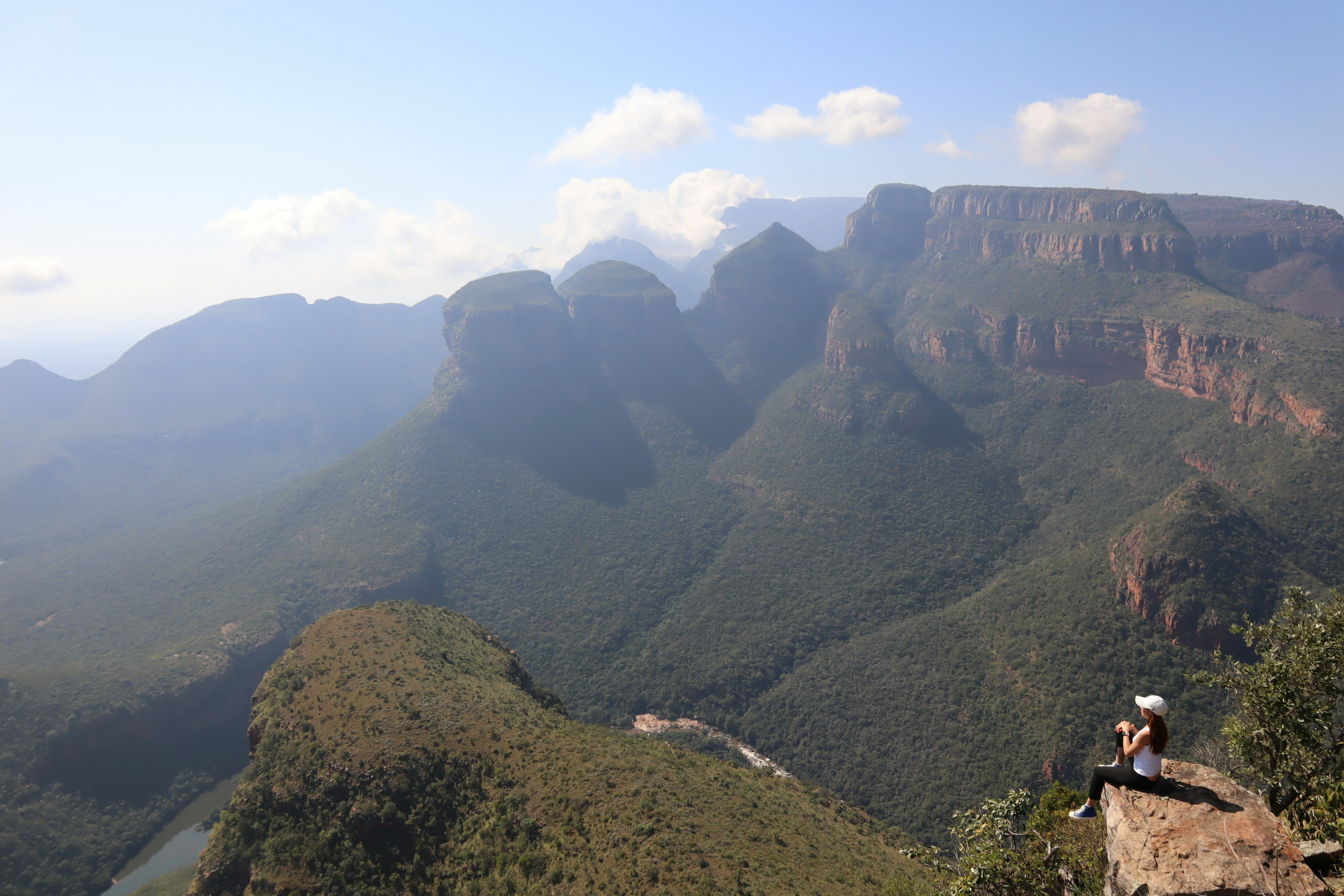 Silhouette d'une personne contemplant des montagnes verdoyantes