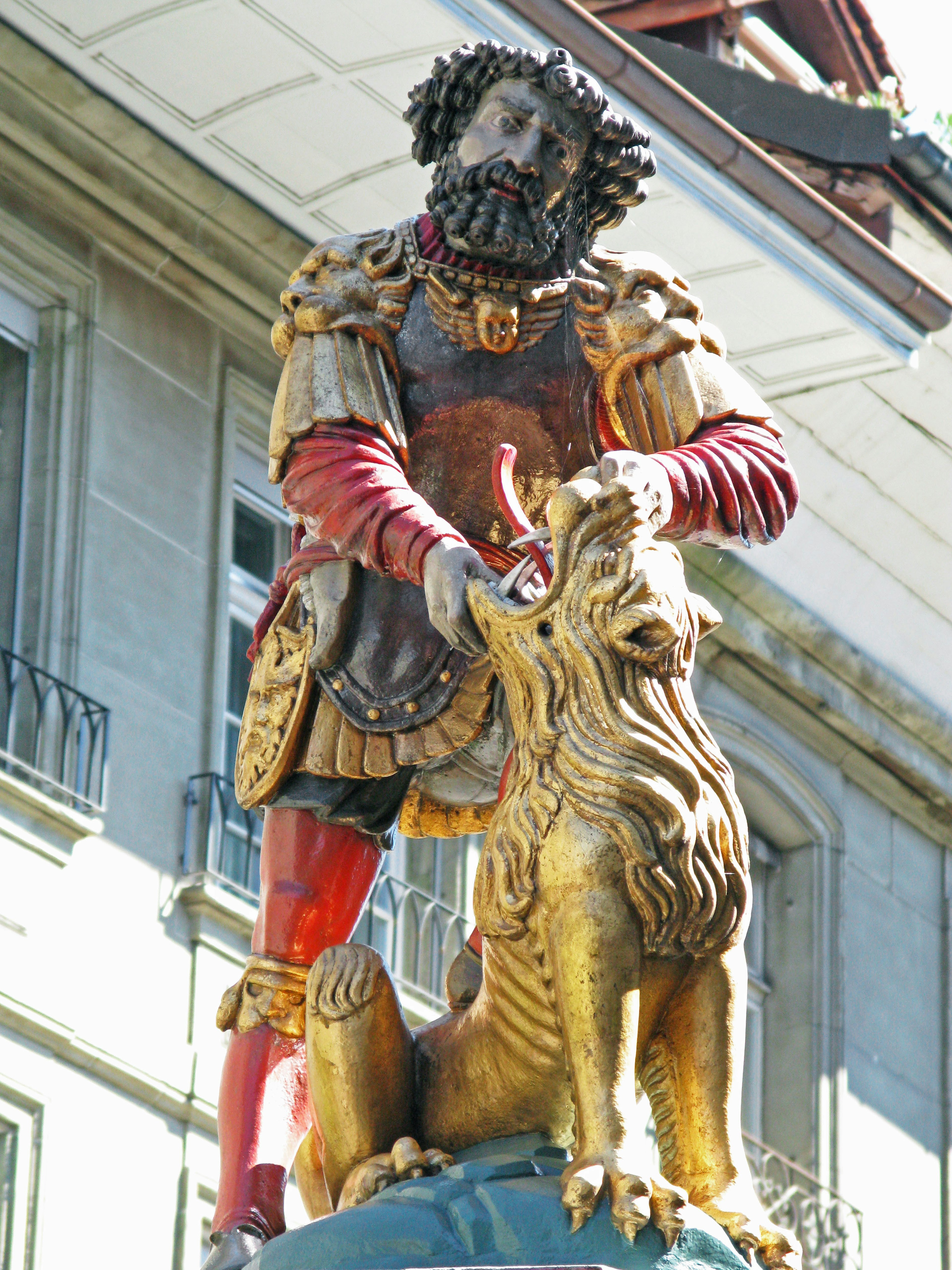 Statua di un guerriero che tiene un leone dorato