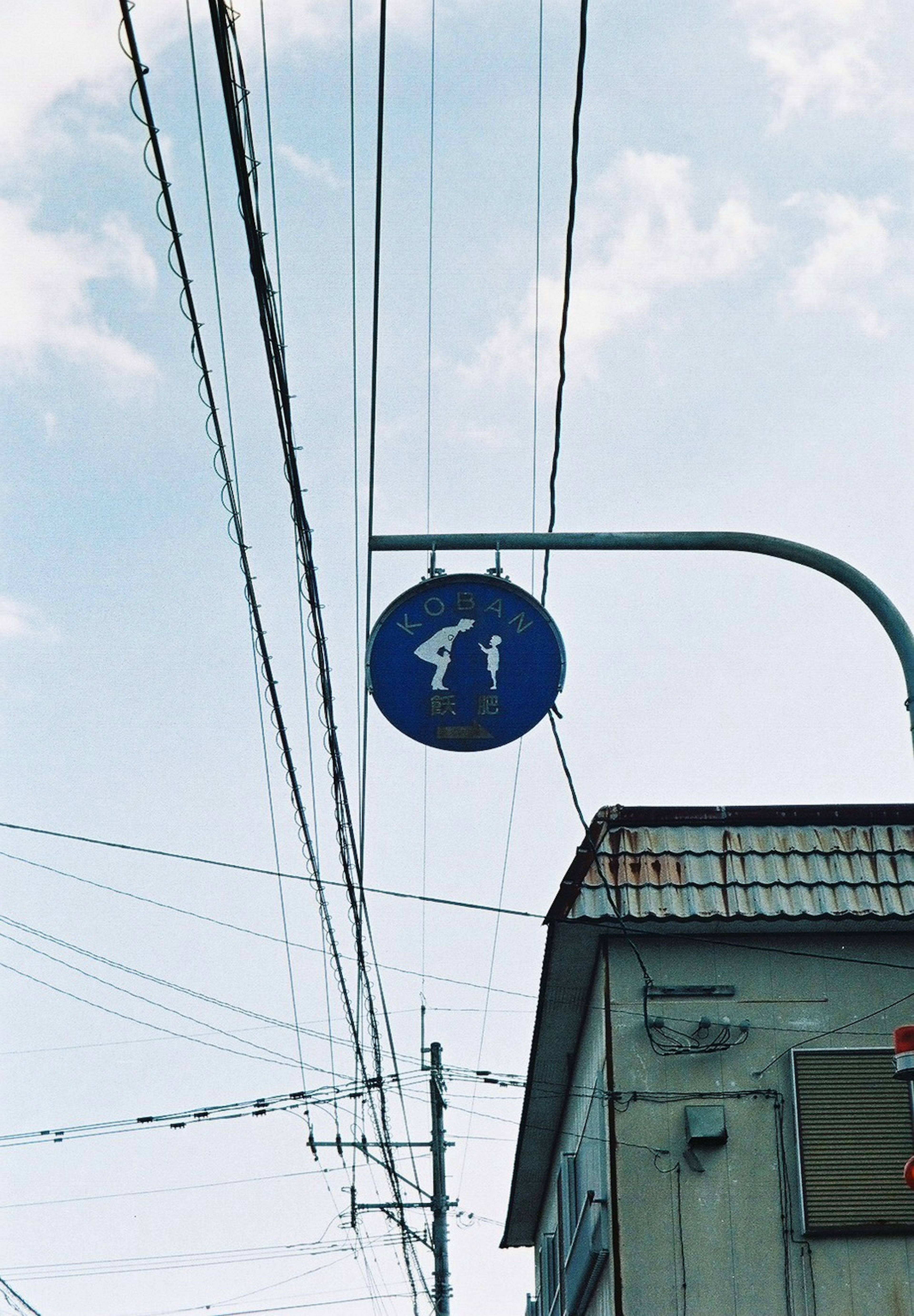 青い歩行者信号の標識が空に浮かんでいる