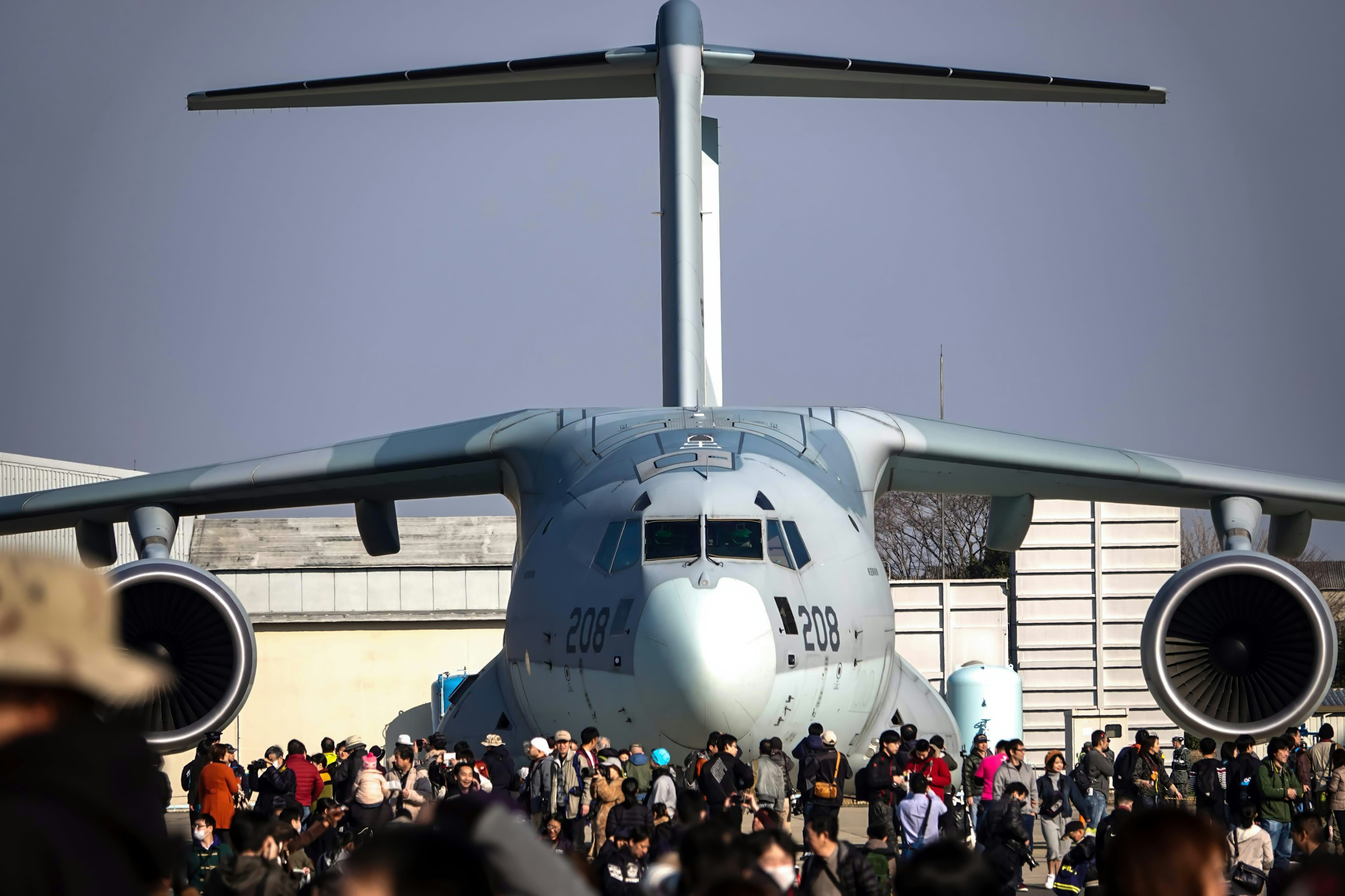 Large transport aircraft facing a crowd of people